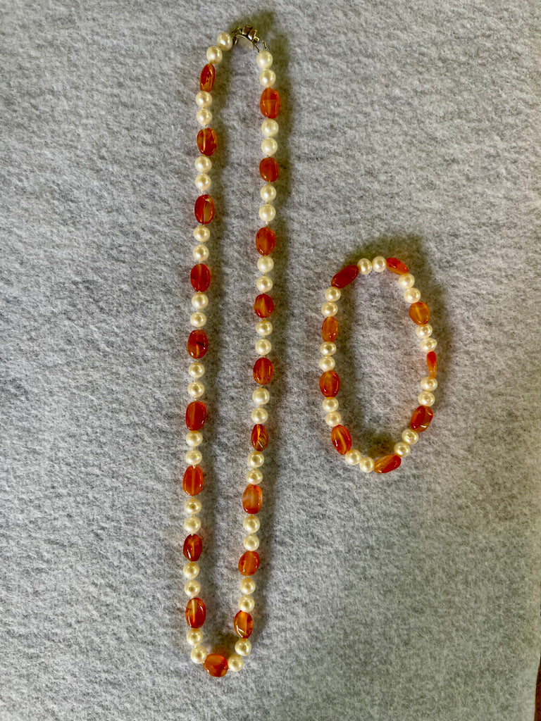 Necklace with White Pearls and oval Carnelian beads with matching stretchy bracelet on a white cloth