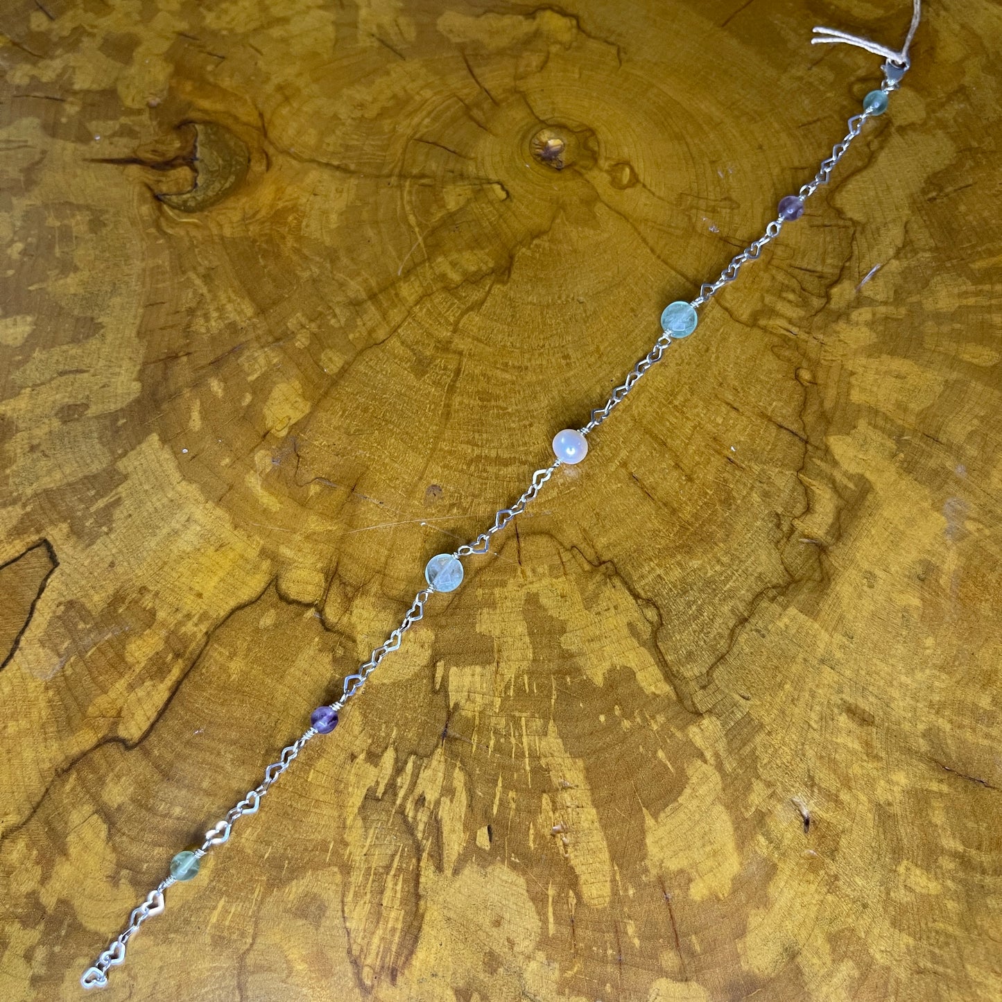 Fluorite and Freshwater Pearl on Sterling Silver Heart chain, 9 inch with 1/2 inch extender and Sterling Silver Lobster clasp on a wooden surface