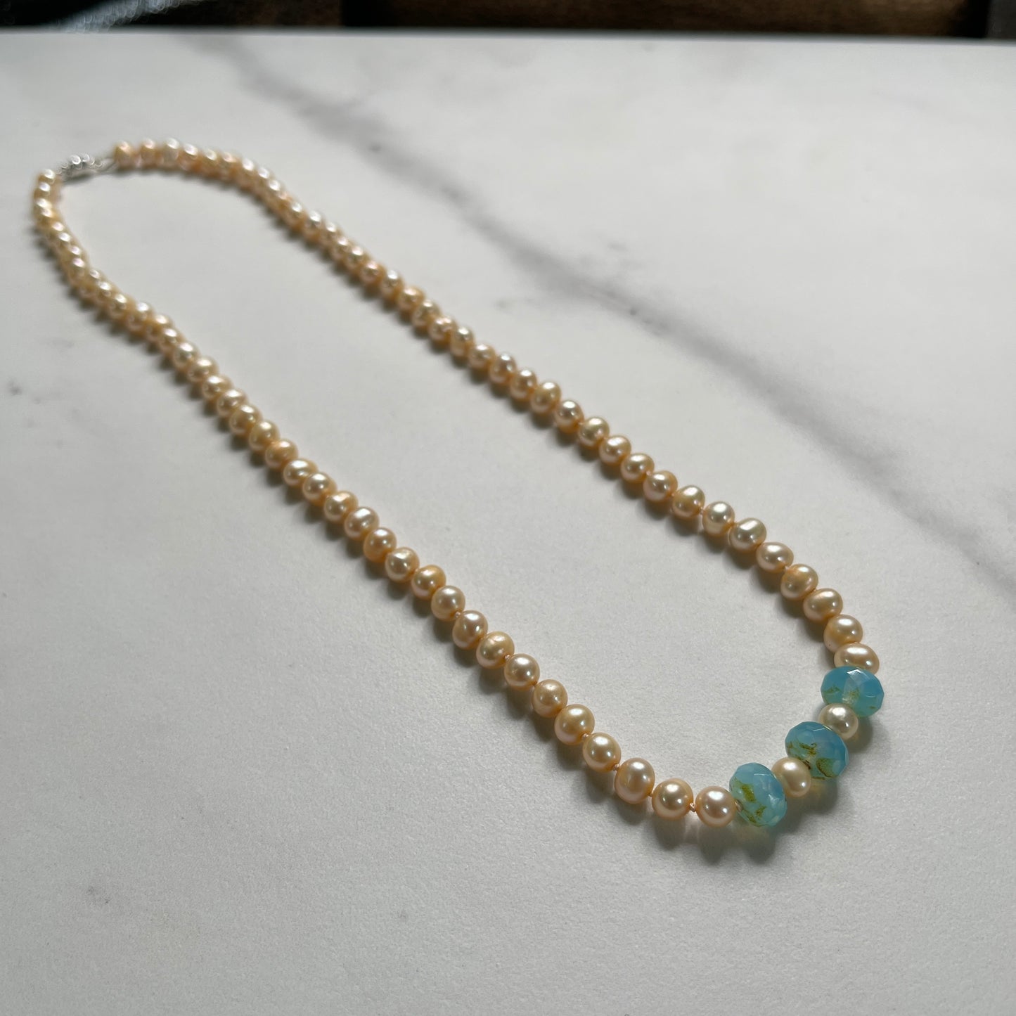 Pink pearl necklace with Blue chalcedony beads on marble