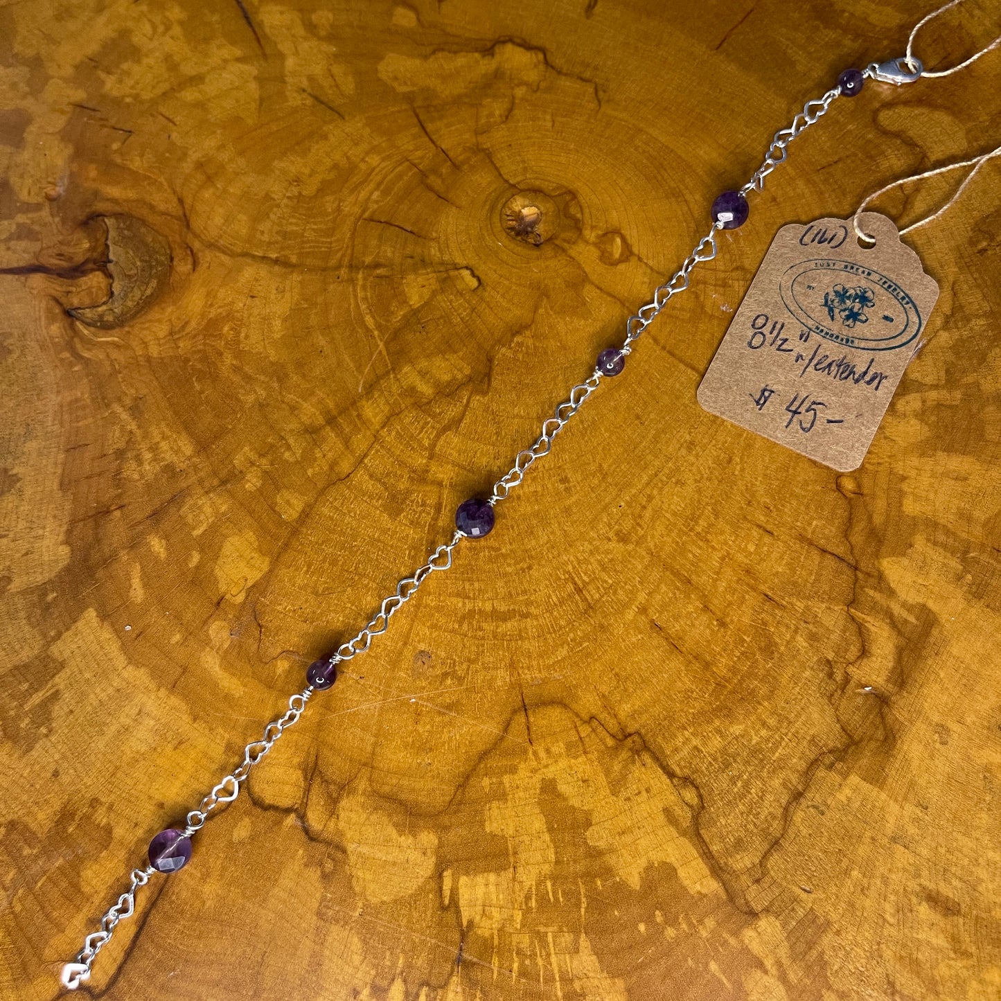 Amethyst on Sterling Silver heart Chain, 8 inches with 1/2 inch extender and Sterling Silver lobster clasp on wooden surface with tag