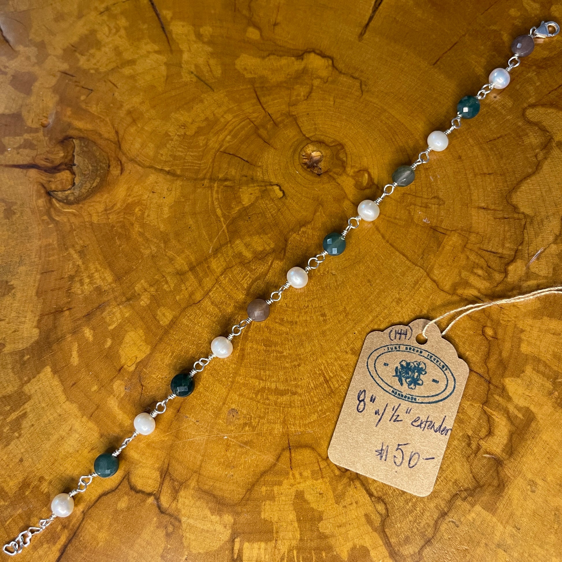 Faceted Multi colored Jasper and White Freshwater Pearls on Sterling Silver wire with Sterling Silver Lobster clasp, 8" with Sterling 1" heart chain extender on wood