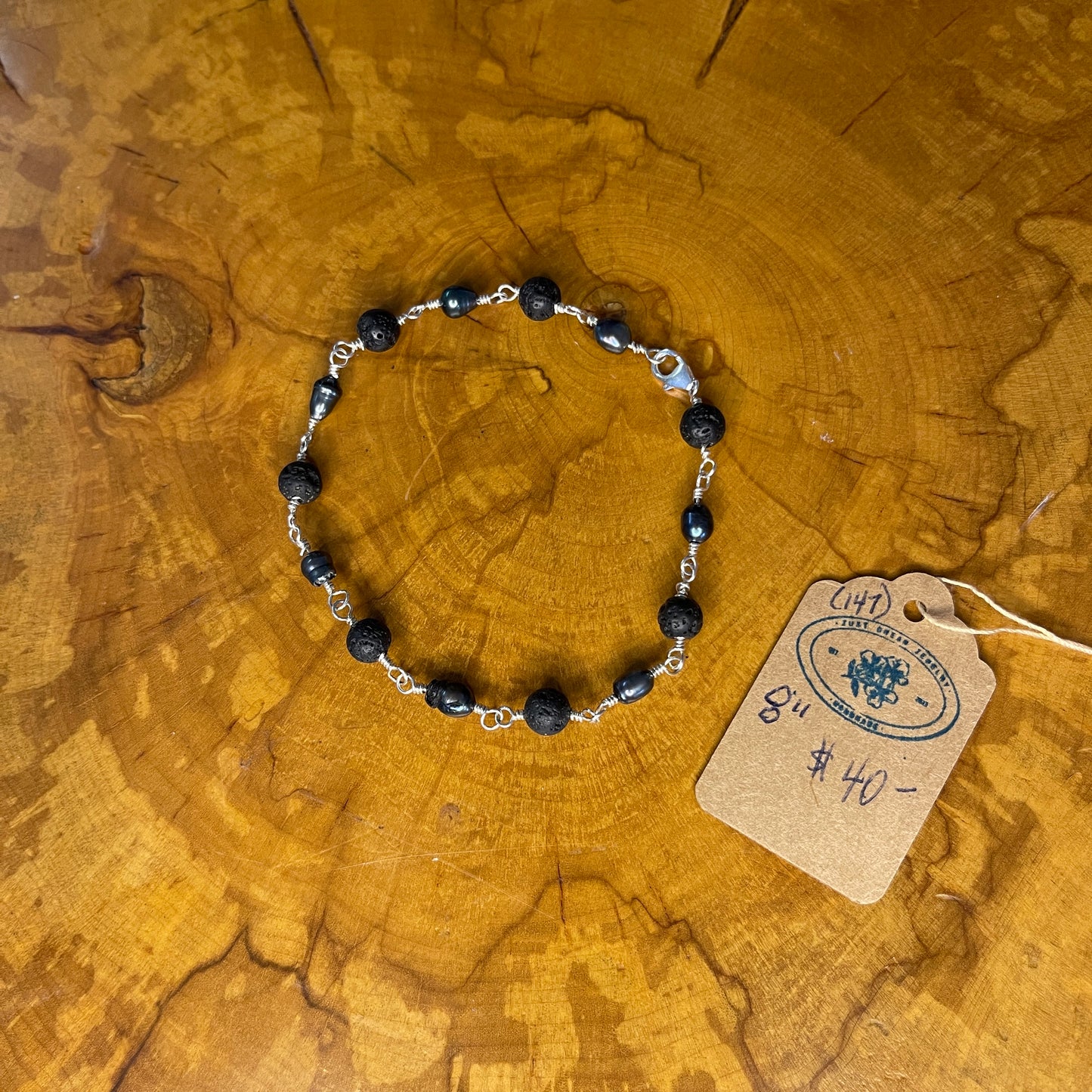 Dark Peacock Freshwater Pearls and Lava beads on Sterling Silver wire with Sterling Silver Lobster clasp, 8" on wood