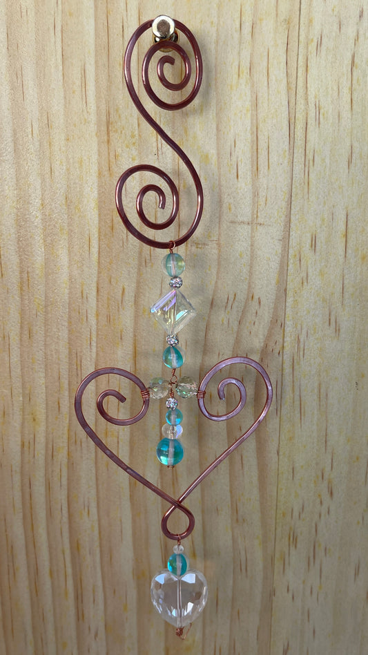 Heart shaped Decorative metal wall/window Suncatchers with Blue opalescent beads and Crystal Heart drop on a wooden background