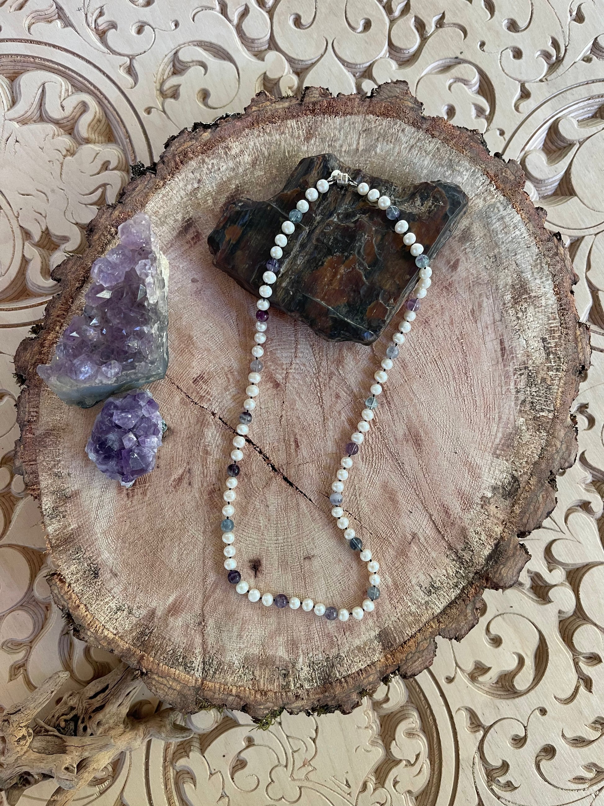White Pearl and Fluorite beaded necklace on a wooden surface