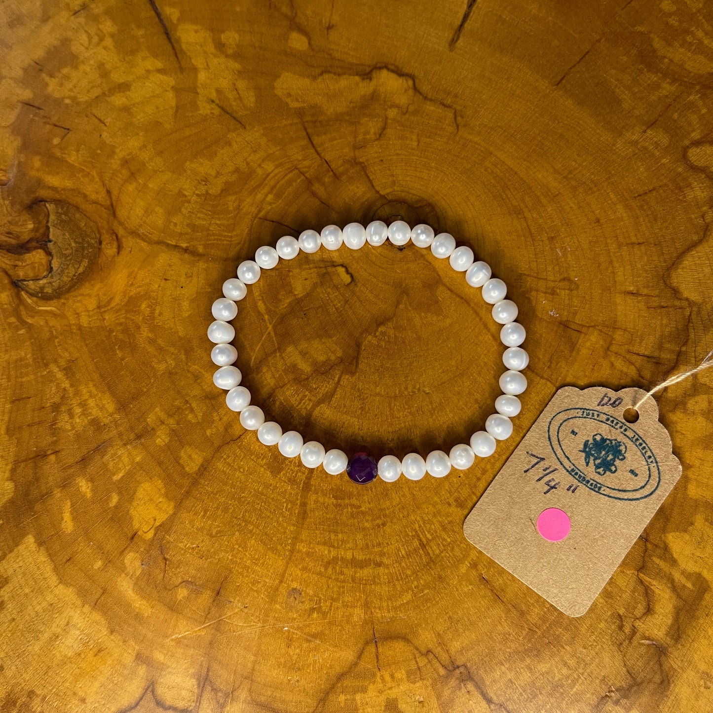 5mm White freshwater pearls with Red Jasper focus bead on elastic, 7 1/4" on wooden surface with tag