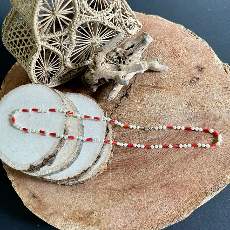 Coral and Pearl necklace on wood with driftwood