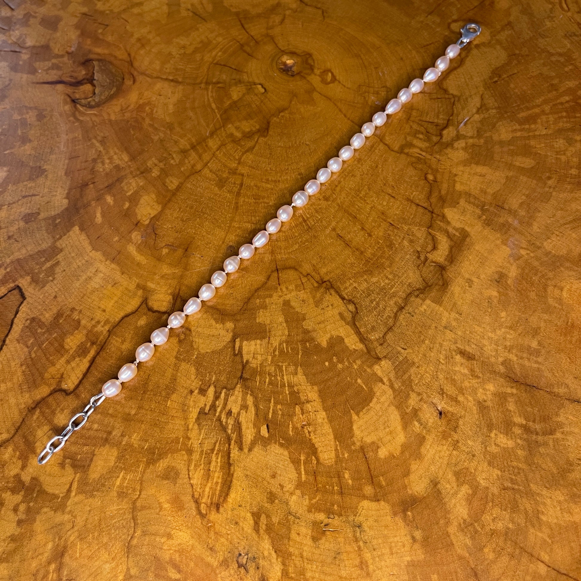 Mauve Freshwater Rice Pearls on Silk,7 3/4" with 1" Sterling Silver extender chain, Sterling Silver Lobster clasp on wood