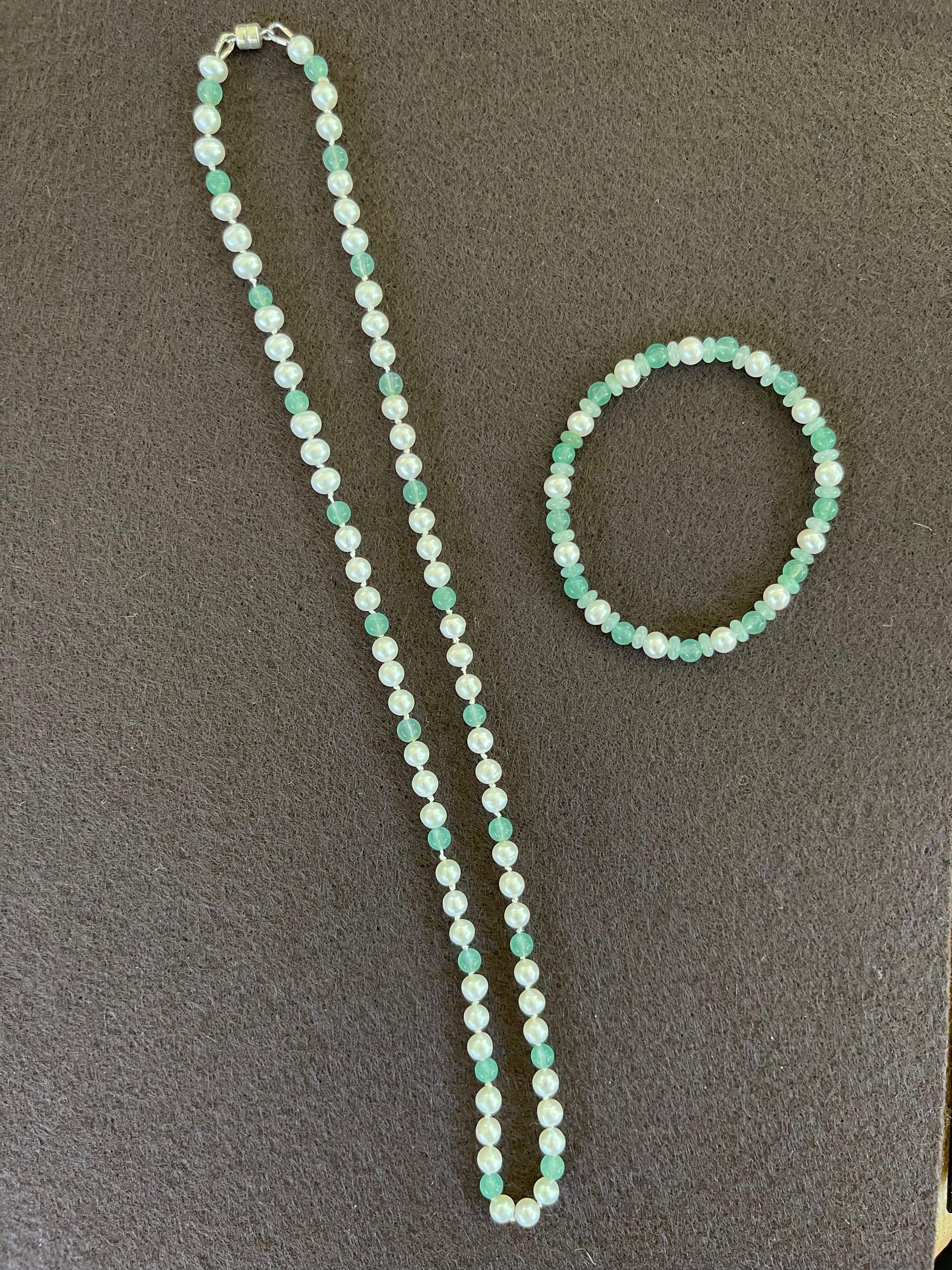 White Pearl and green aventurine beaded necklace and bracelet set on grey backround