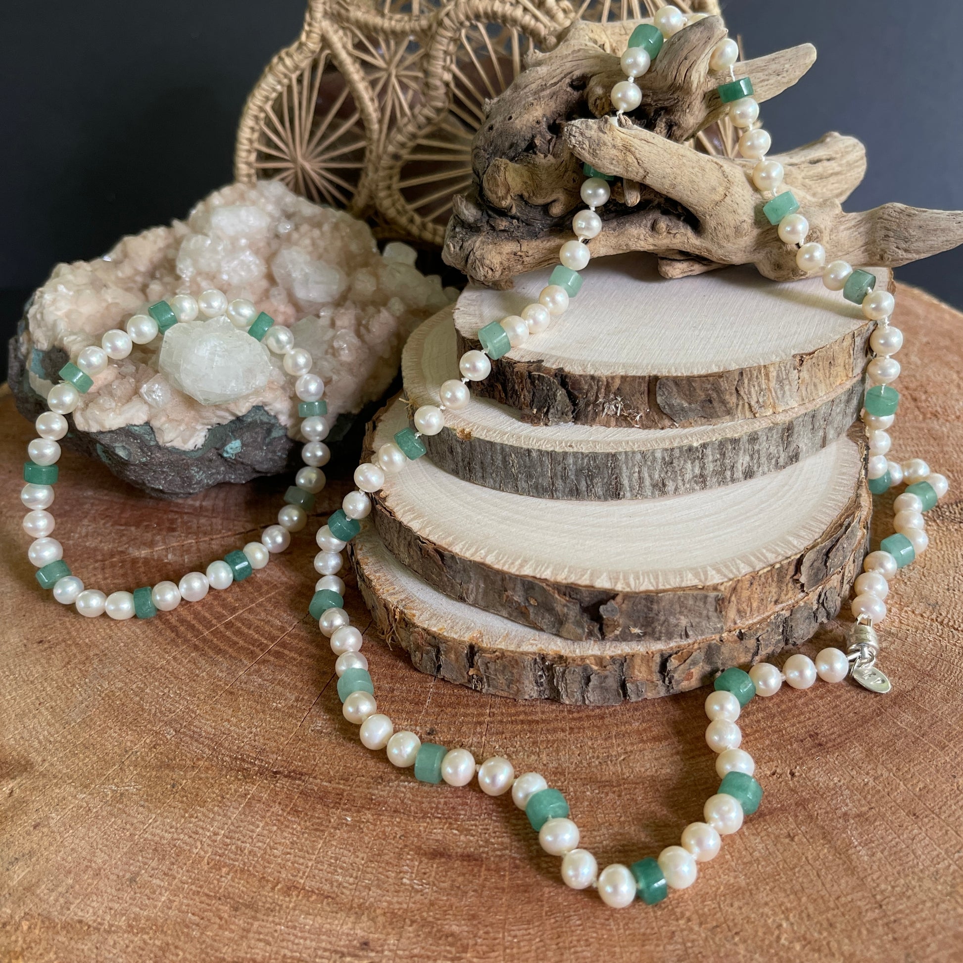 White round Pearls and Aventurine heishi discs beaded necklace and matching stretchy bracelet on a wooden surface with natural elements