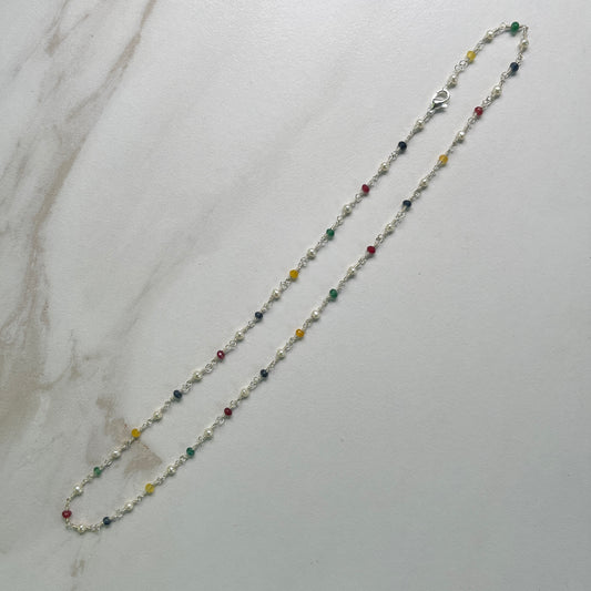 Necklace with multicolored  Jade and white Pearl beads on Sterling wire on a marble surface
