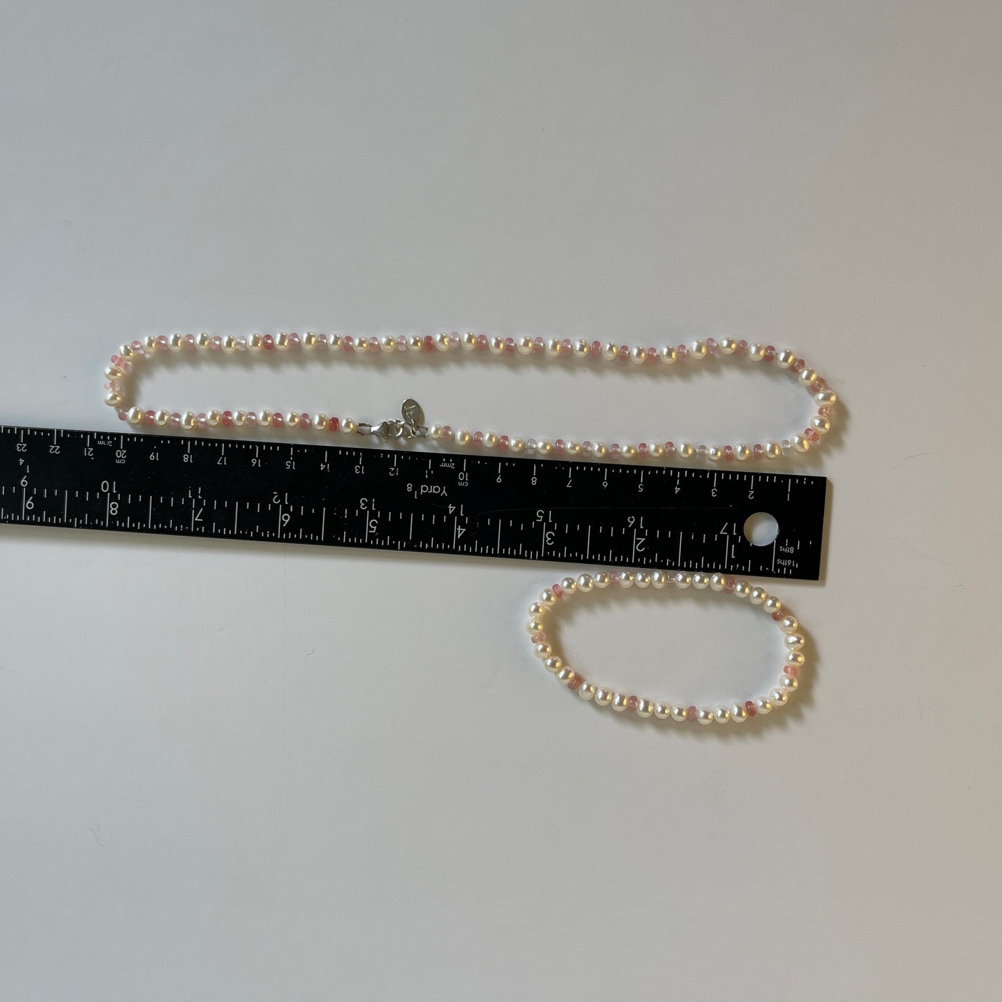 White Pearl  and strawberry quartz necklace and matching stretchy bracelet on a white surface with ruler