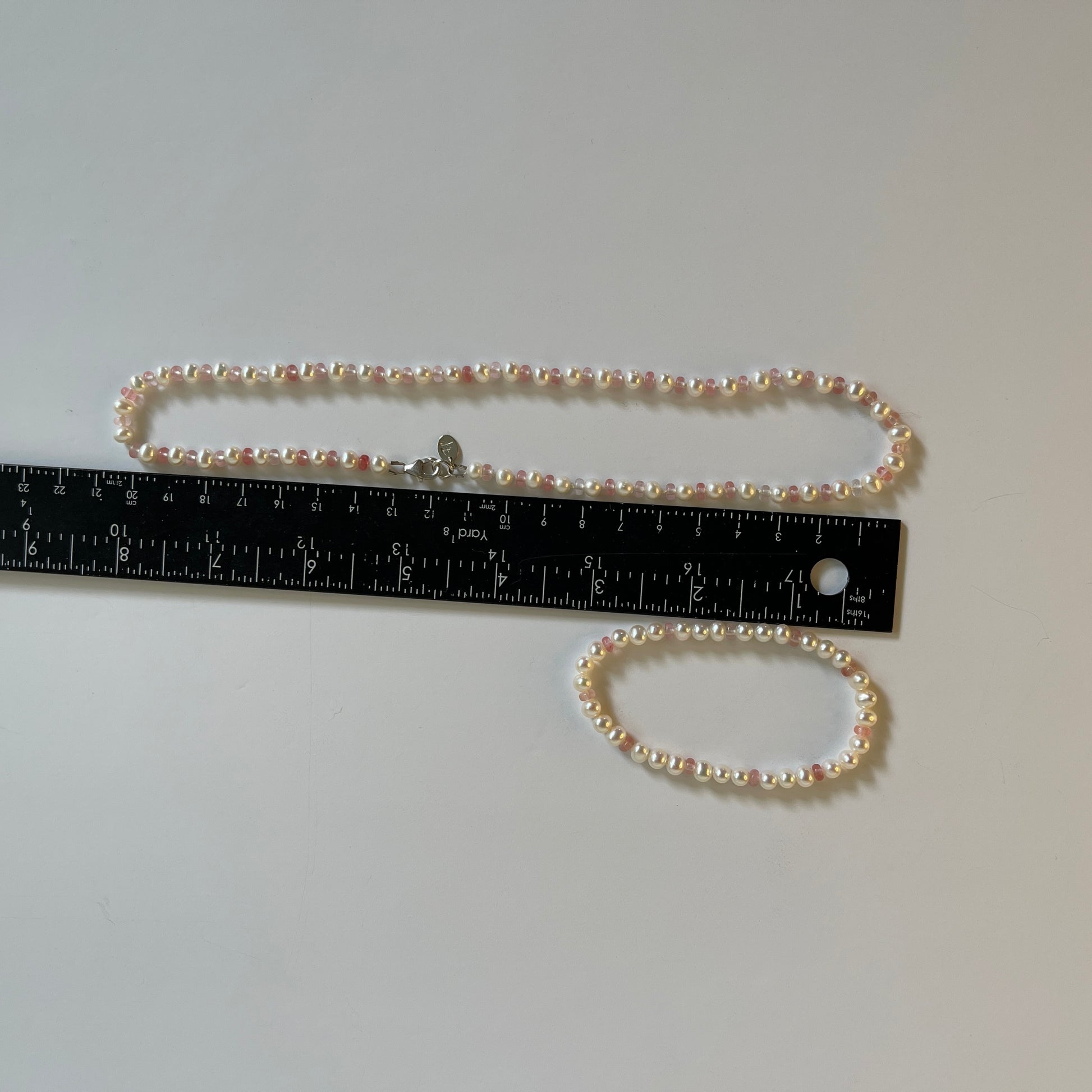 White Pearl  and strawberry quartz necklace and matching stretchy bracelet on a white surface with ruler