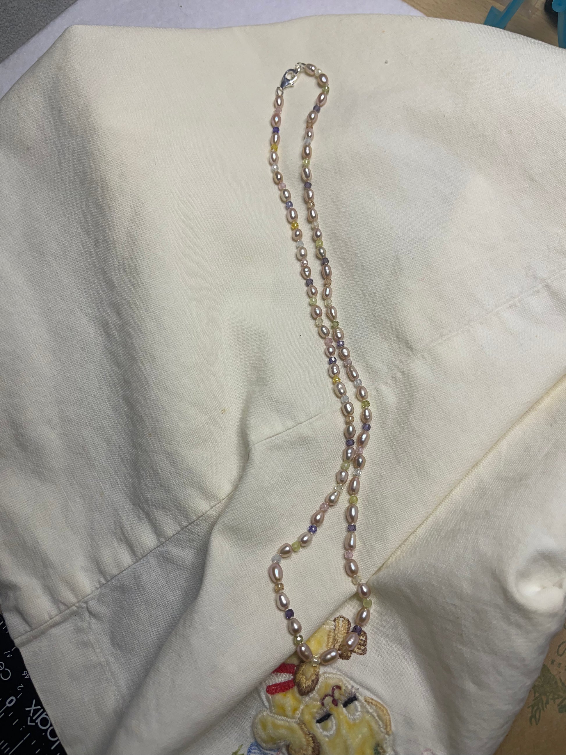 Pearl necklace on a light-colored fabric background