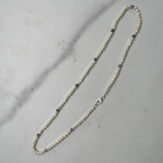 Pearl necklace with Amethyst beads on a marble surface
