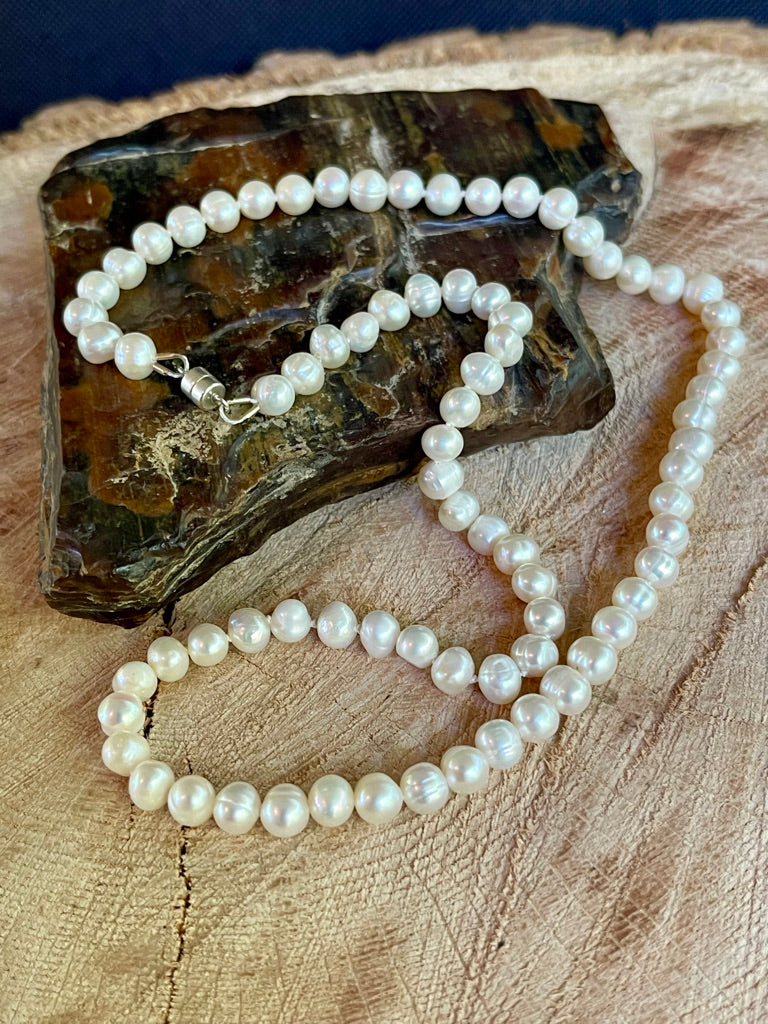 Pearl necklace on a wooden surface with a dark background