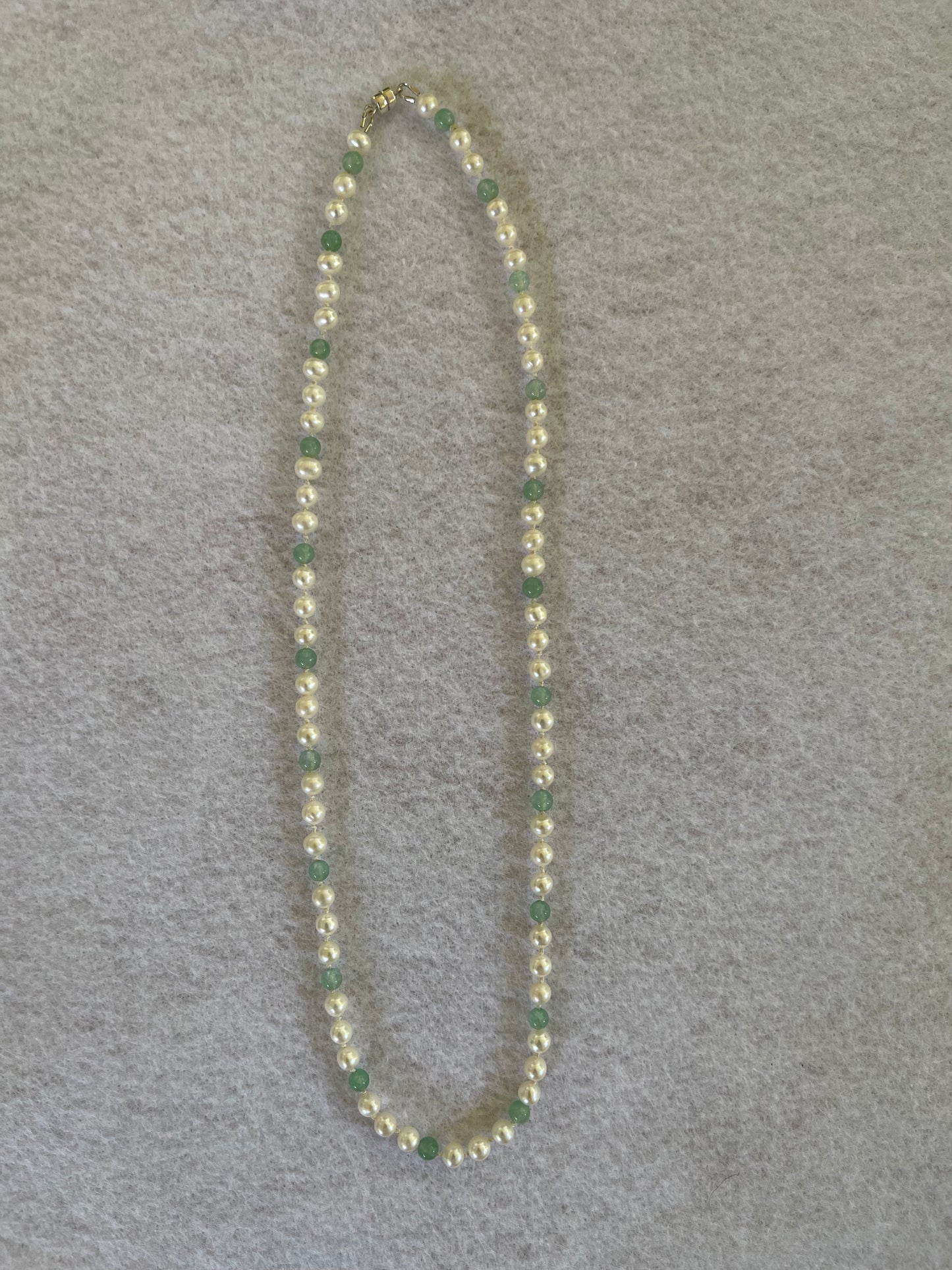 green aventurine beaded necklace with white freshwater Pearls on white cloth