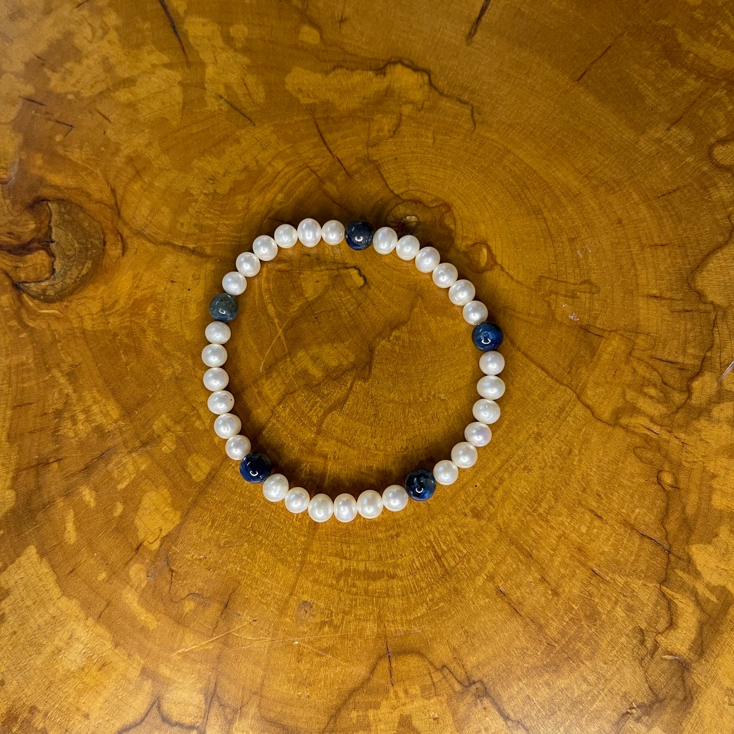 Freshwater Pearls with Kyanite on elastic, 7 1/4" on wooden surface