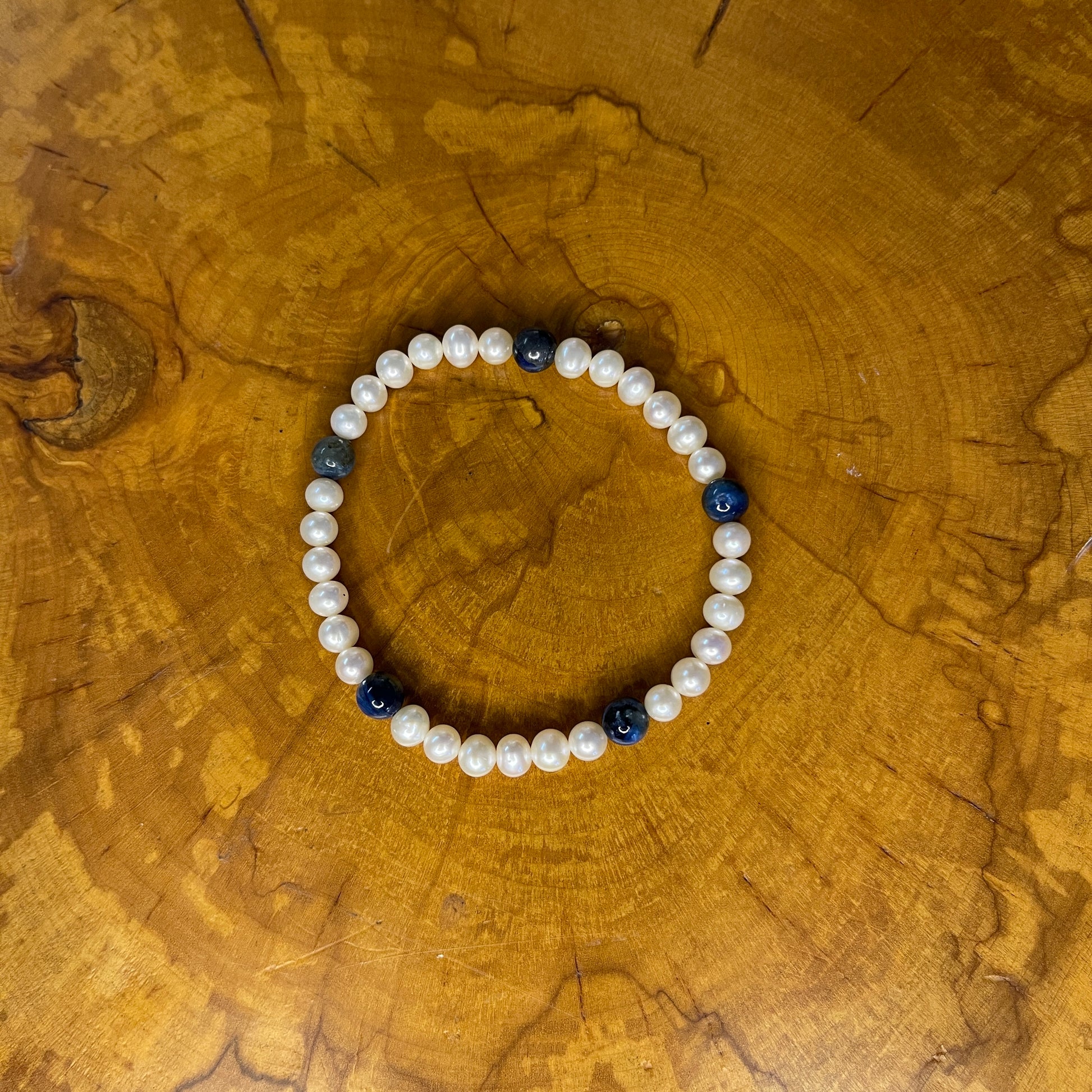 Freshwater Pearls with Kyanite on elastic, 7 1/4" on wooden surface