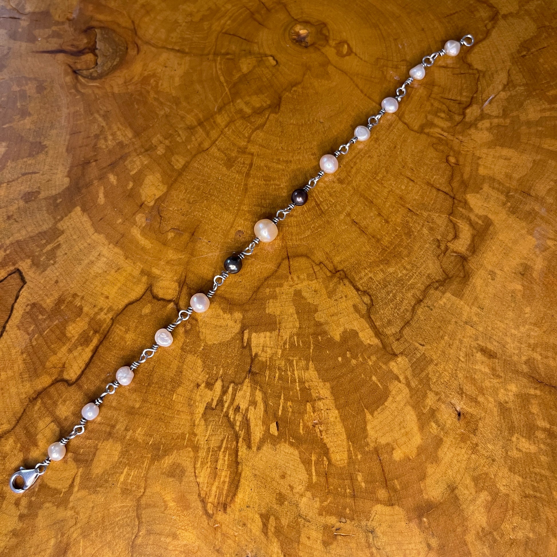 Freshwater White, Mauve and Peacock Pearls on Sterling Silver wire with Sterling Silver Lobster clasp, 8" on wood