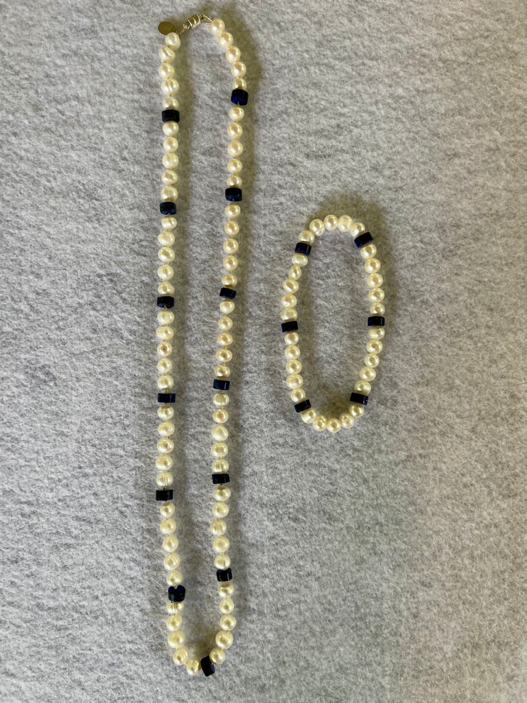 White Pearl and Lapis Lazuli heishi beaded  necklace matching stretchy bracelet on a white cloth