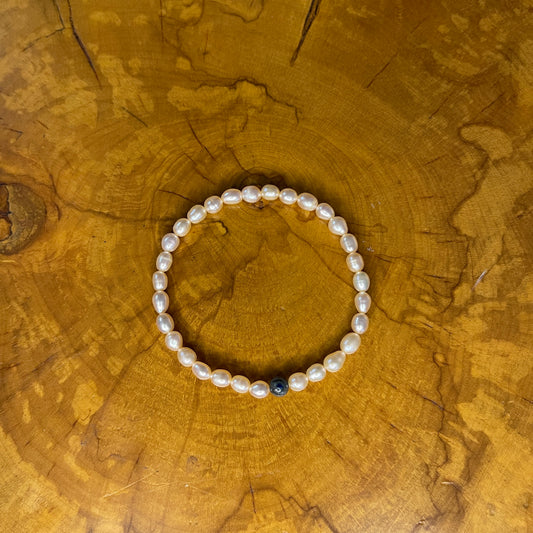 Mauve freshwater Pearls with Blue kyanite focus bead on elastic, 7 1/2" on elastic, 7 1/2" on wooden surface