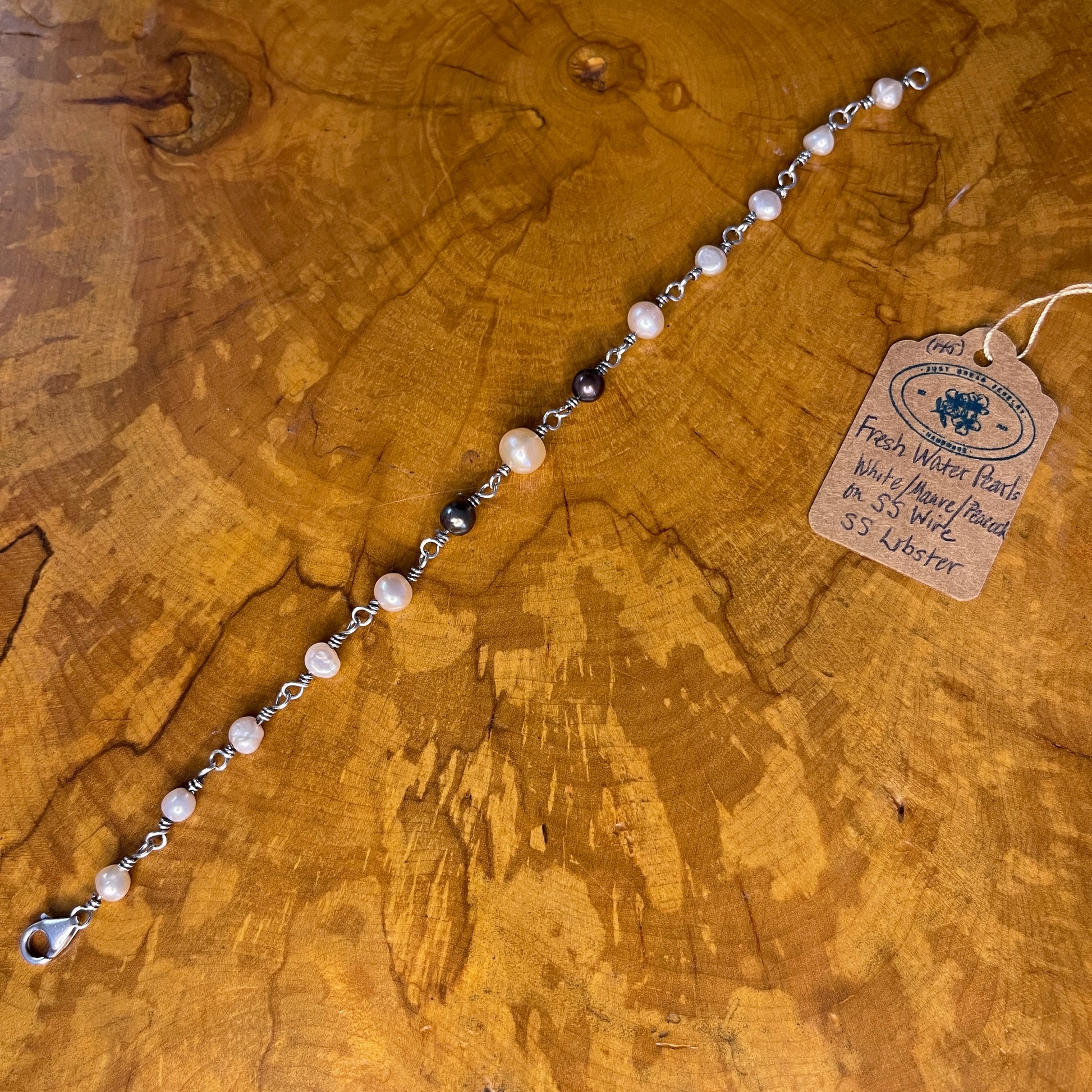 Freshwater White, Mauve and Peacock Pearls on Sterling Silver wire with Sterling Silver Lobster clasp, 8" on wood