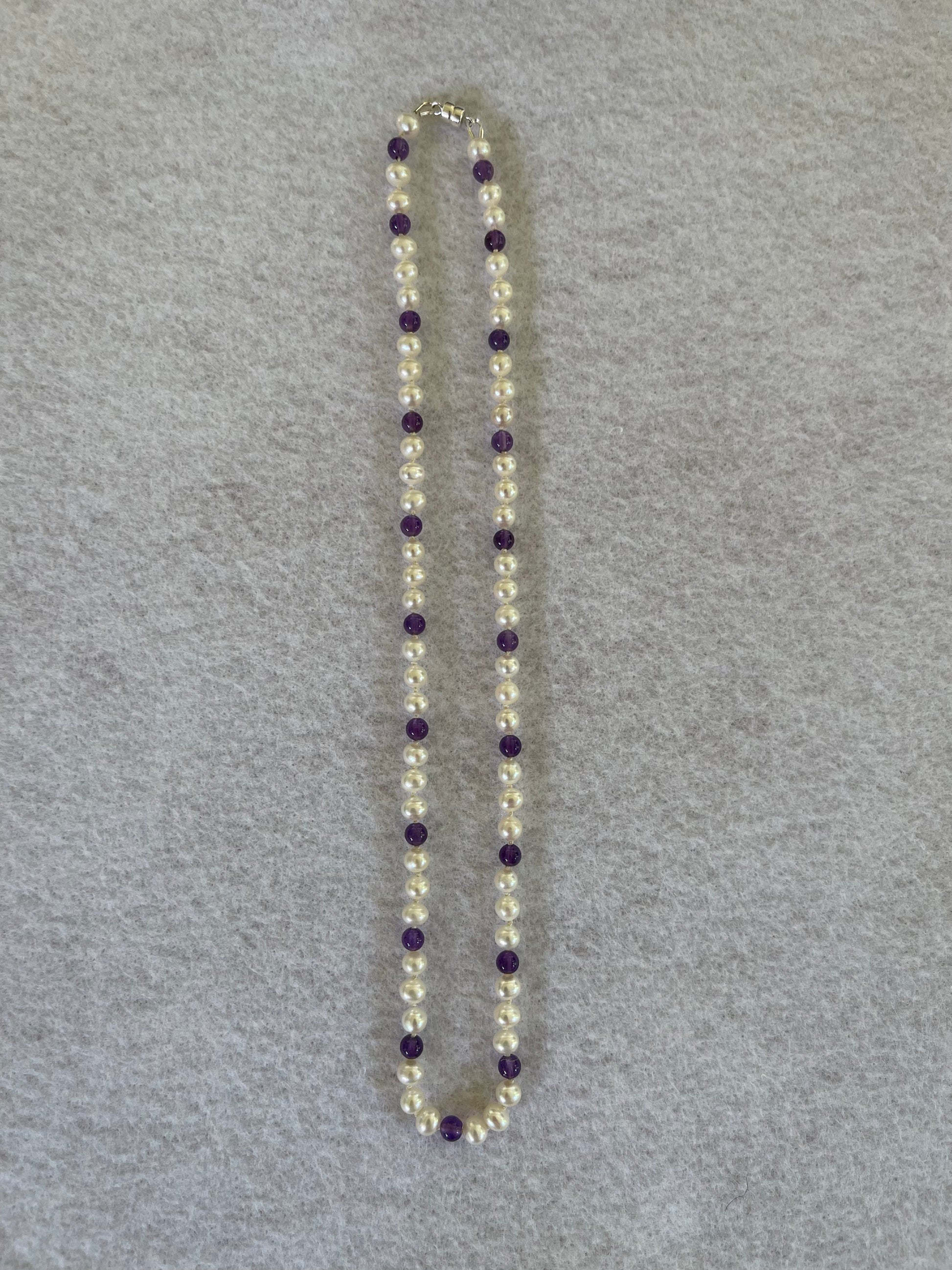 Necklace with White Pearls and Amethyst beads on a white cloth