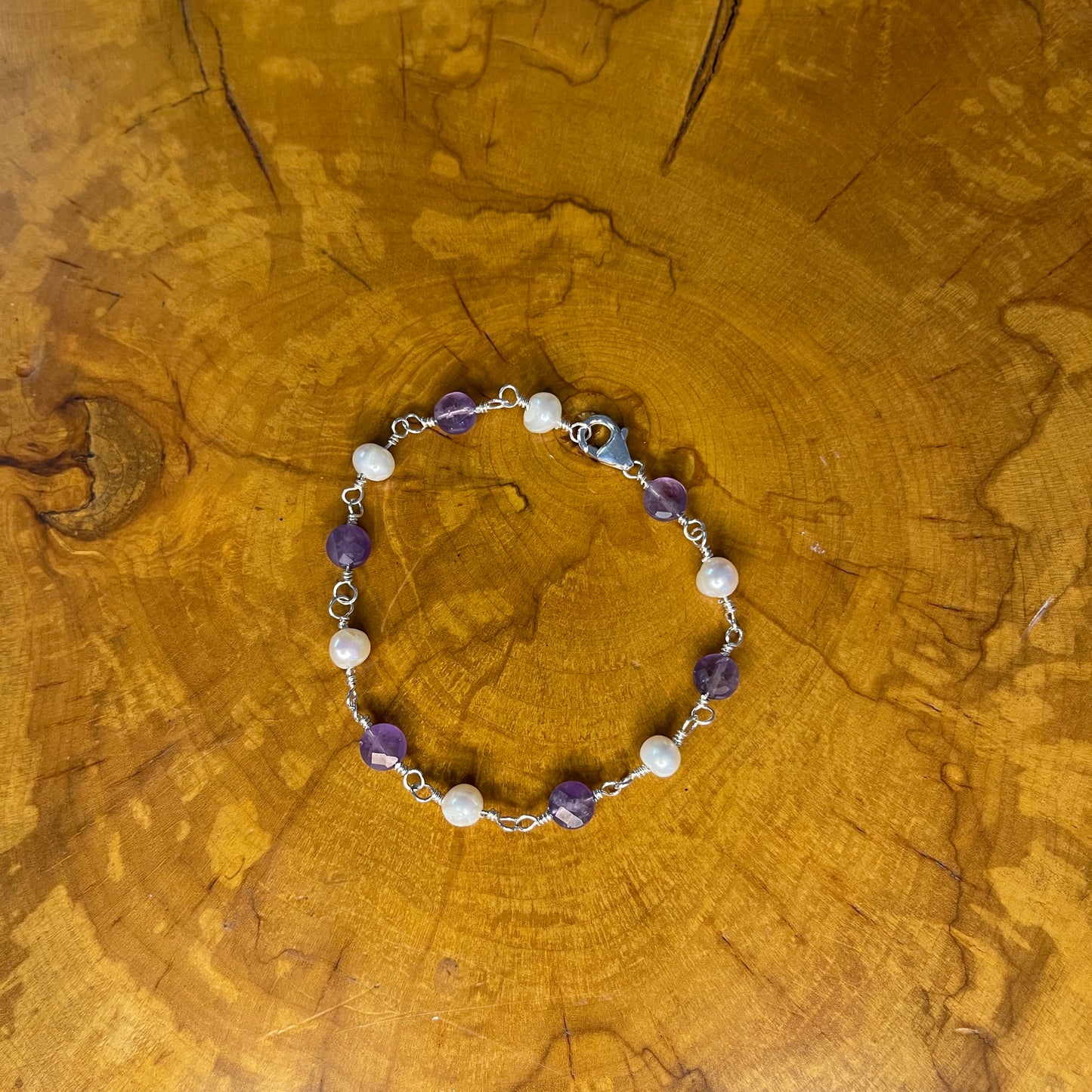 Faceted Amethyst and freshwater White pearls on Sterling Silver wire, 7 1/4" Sterling Silver Lobster Clasp on wood