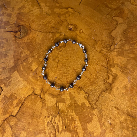 Dark Peacock freshwater Pearls on Sterling Silver wire with Sterling silver lobster clasp, 8" on wood