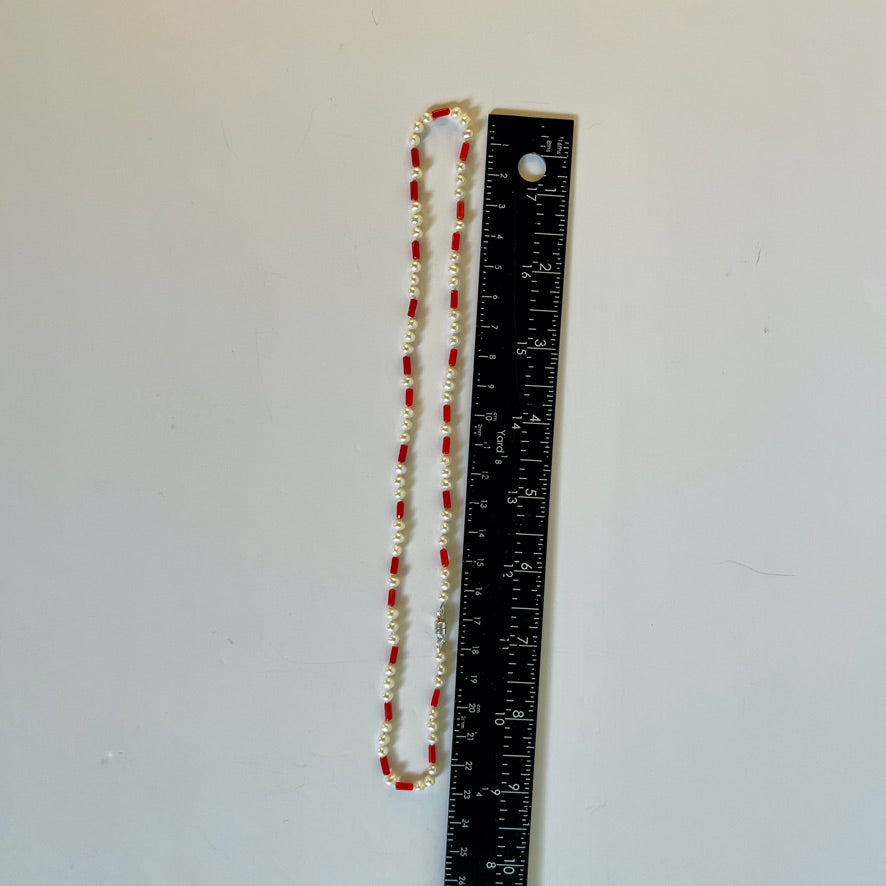 Coral and Pearl necklace on white background with ruler