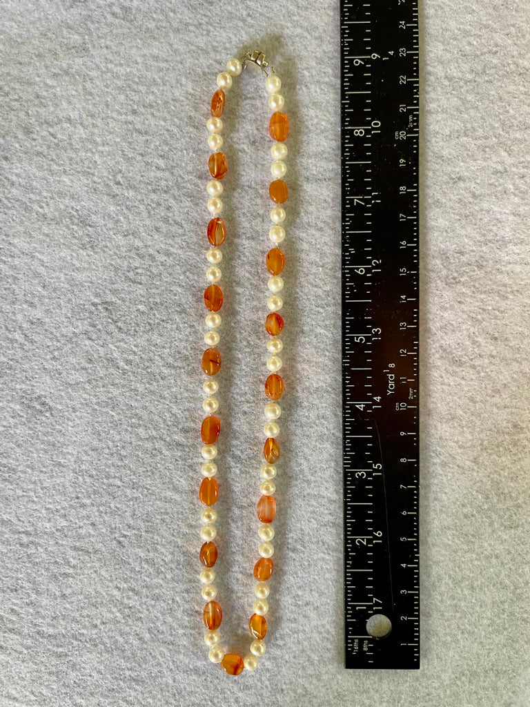 Necklace with White Pearls and oval Carnelian beads (shown without matching stretchy bracelet) on a white surface with ruler