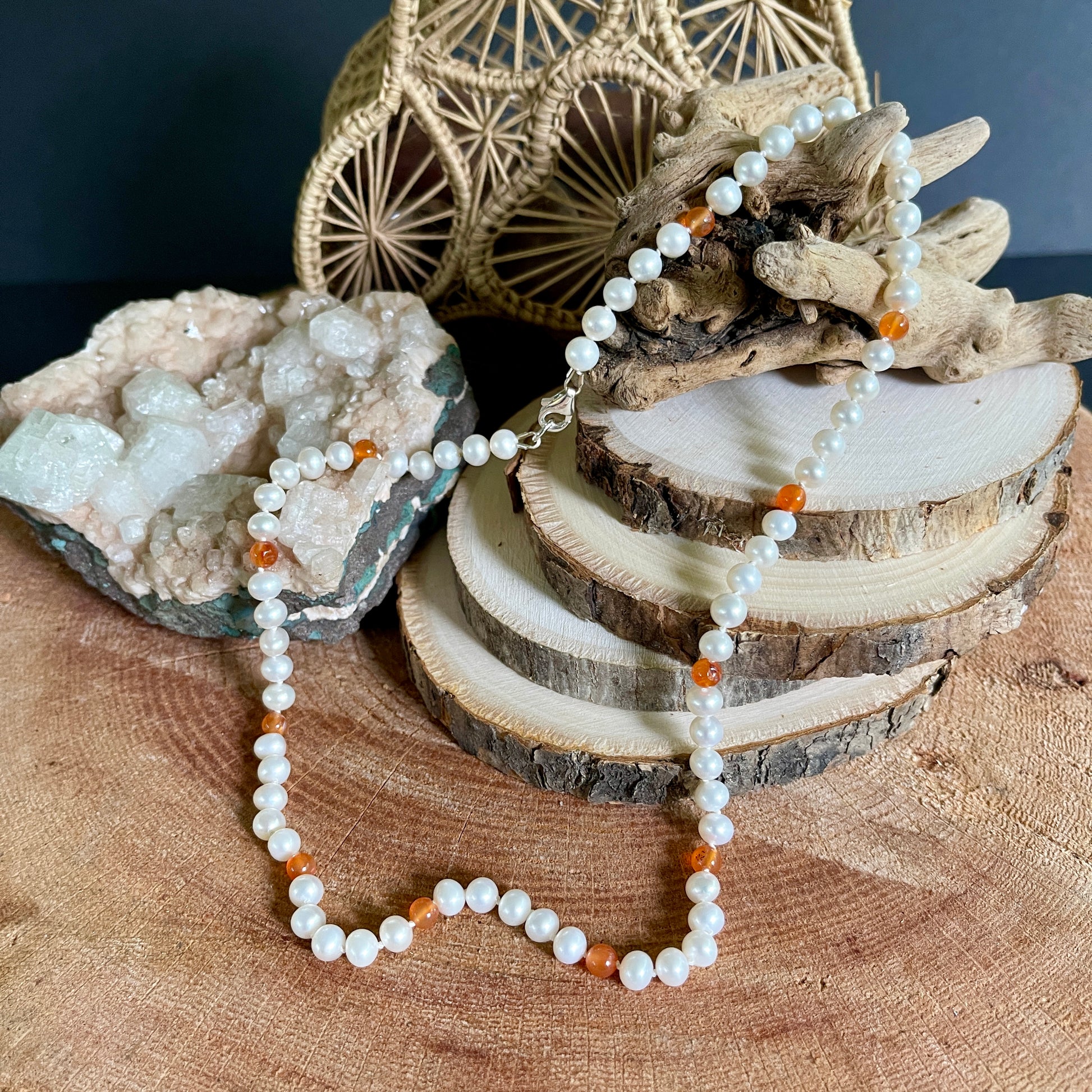 Pearl necklace with Carnelian beads on a wooden surface with natural elements