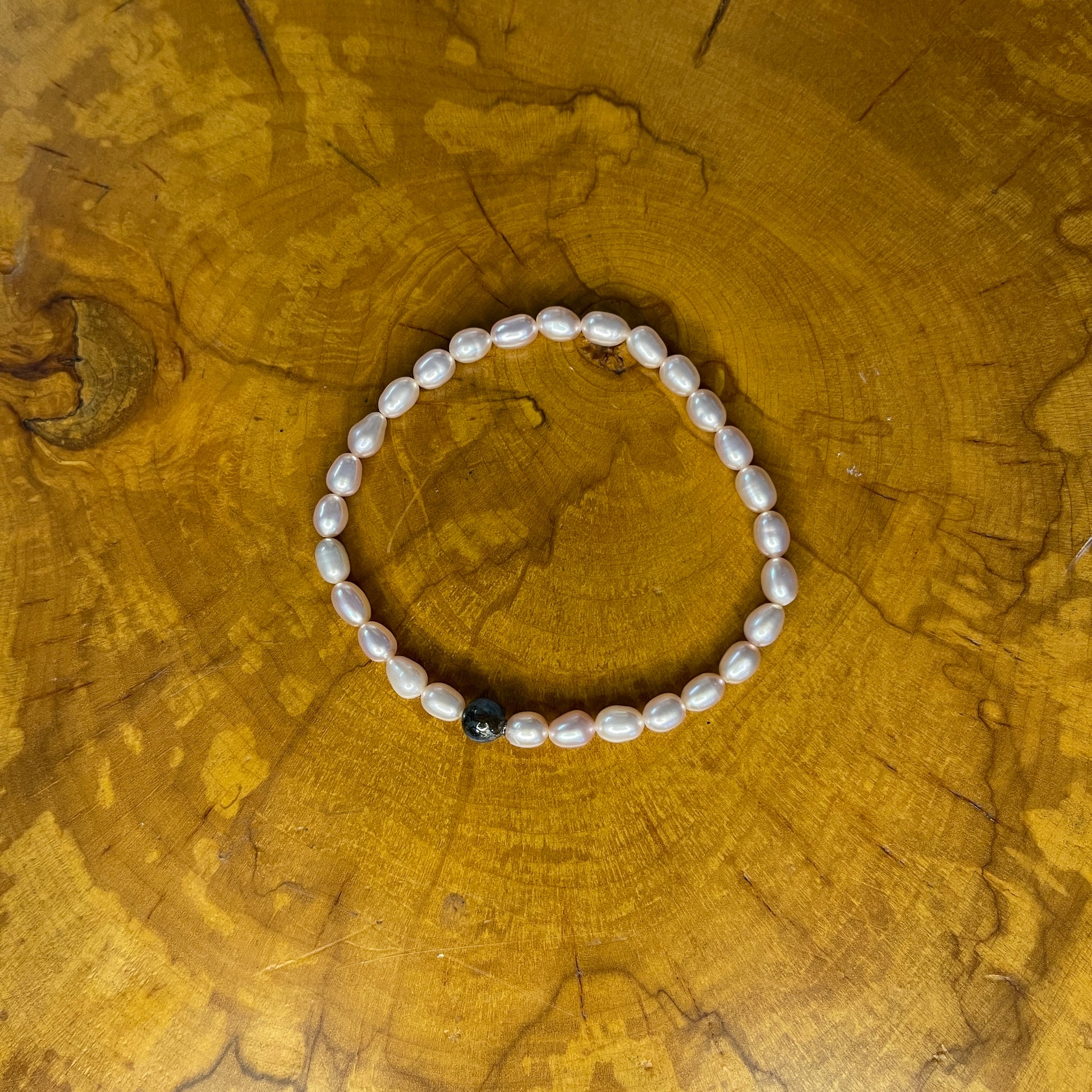 Mauve Freshwater Pearls with Blue Kyanite Bracelet on elastic, 7 1/4" on wooden surface