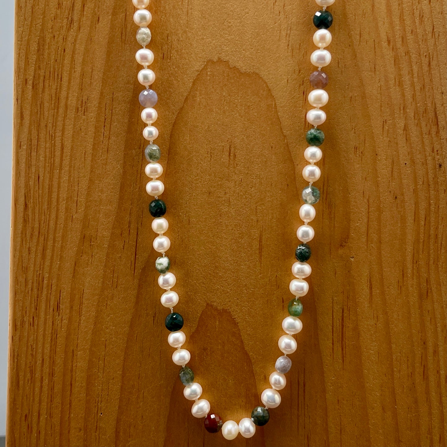 Pearl necklace with multicolored beads on a wooden surface