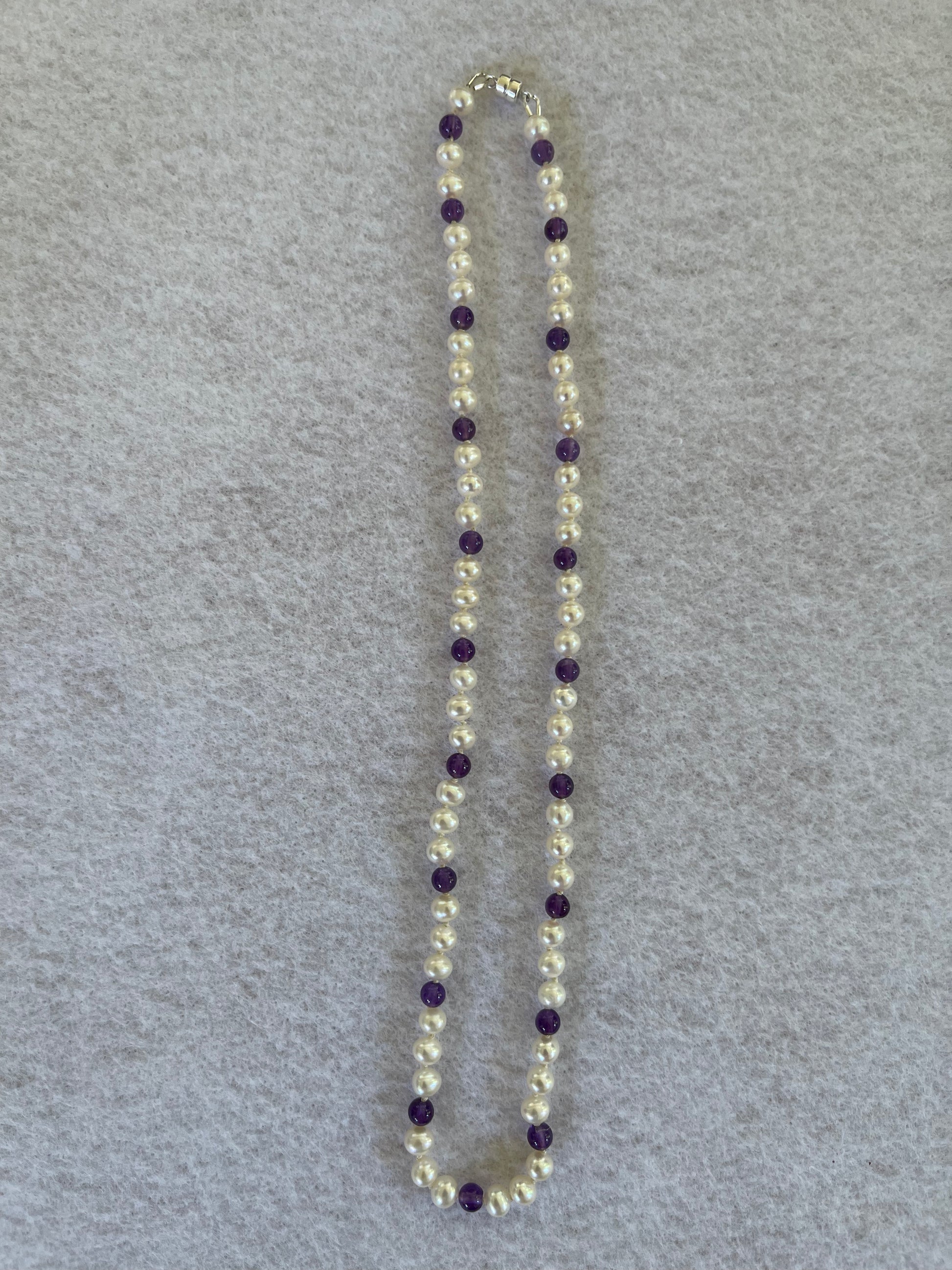 Necklace with White Pearls and Amethyst beads on a white surface