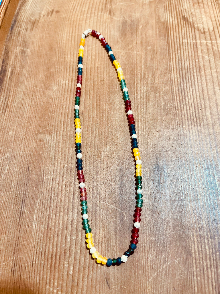 Multi colored Jade and white Pearl Beaded necklace on a wooden surface