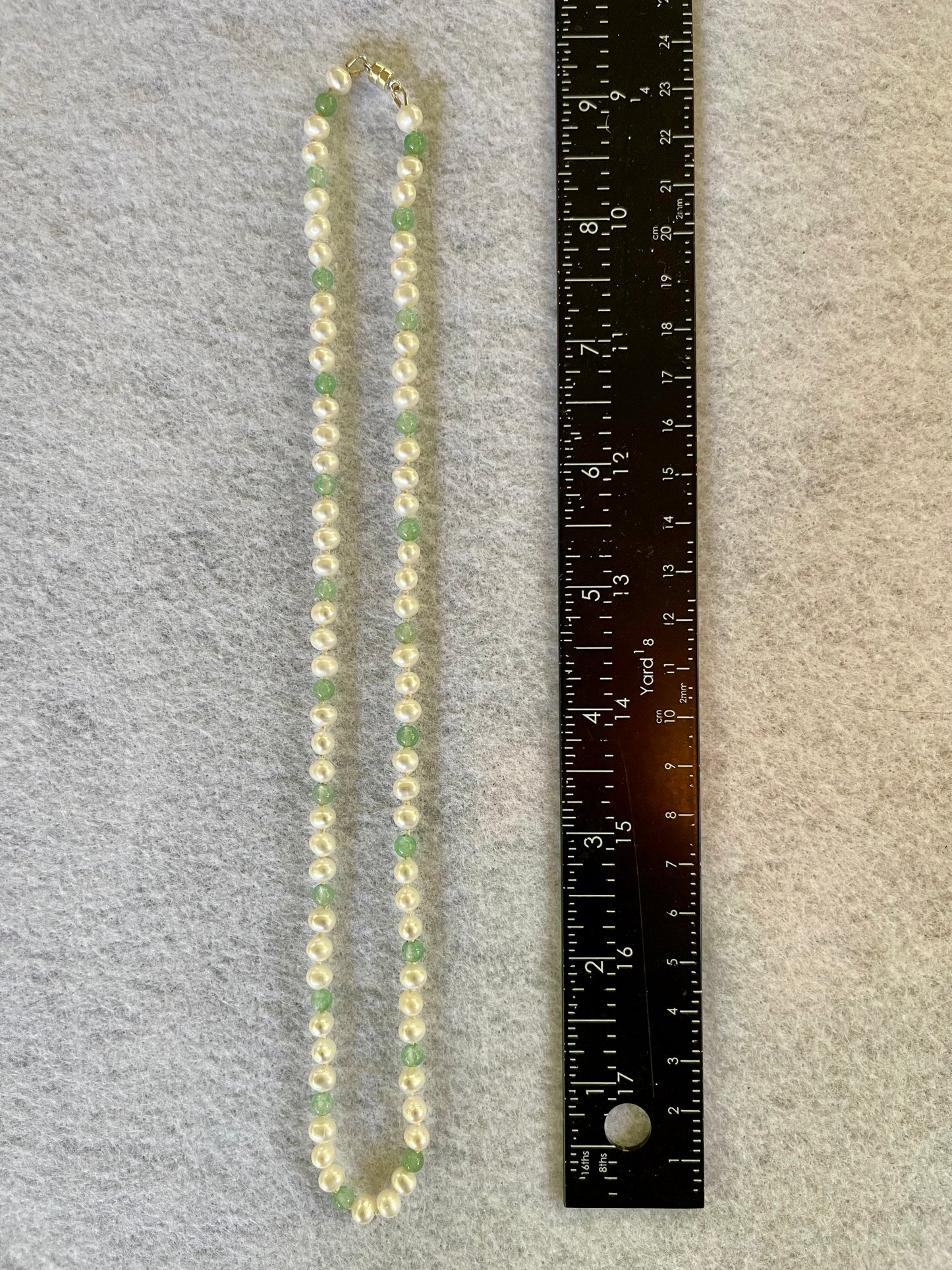Necklace with a ruler for scale on a gray background