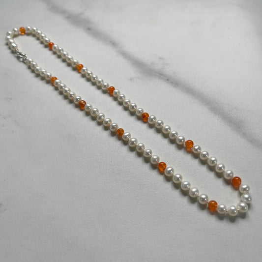 Pearl and Carnelian beaded necklace with on a marble surface