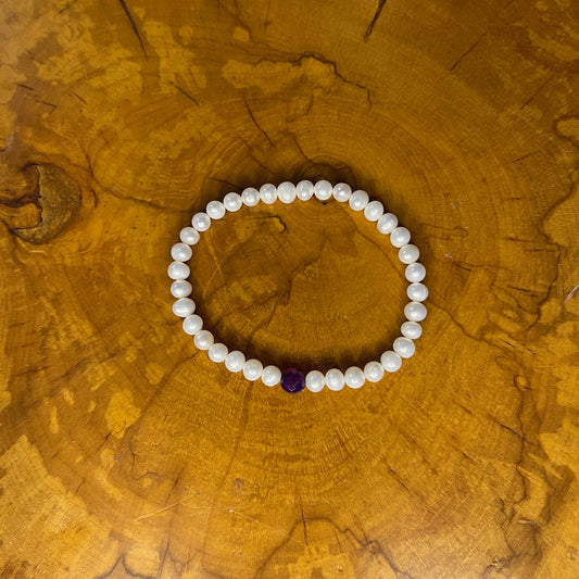 5mm White freshwater pearls with Red Jasper focus bead on elastic, 7 1/4" on wooden surface