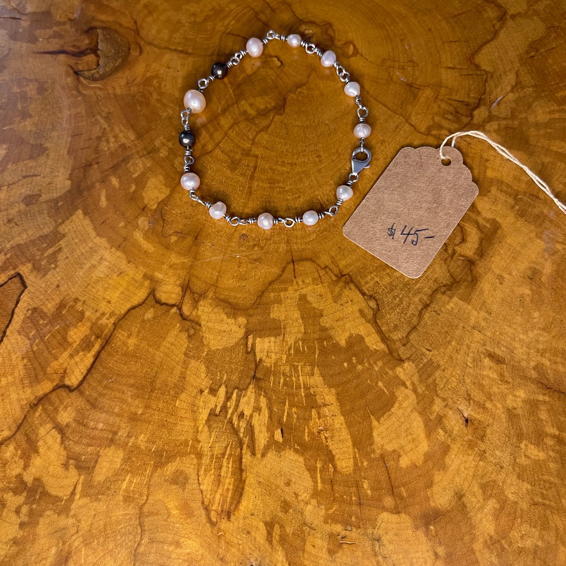 Freshwater White, Mauve and Peacock Pearls on Sterling Silver wire with Sterling Silver Lobster clasp, 8" on wood