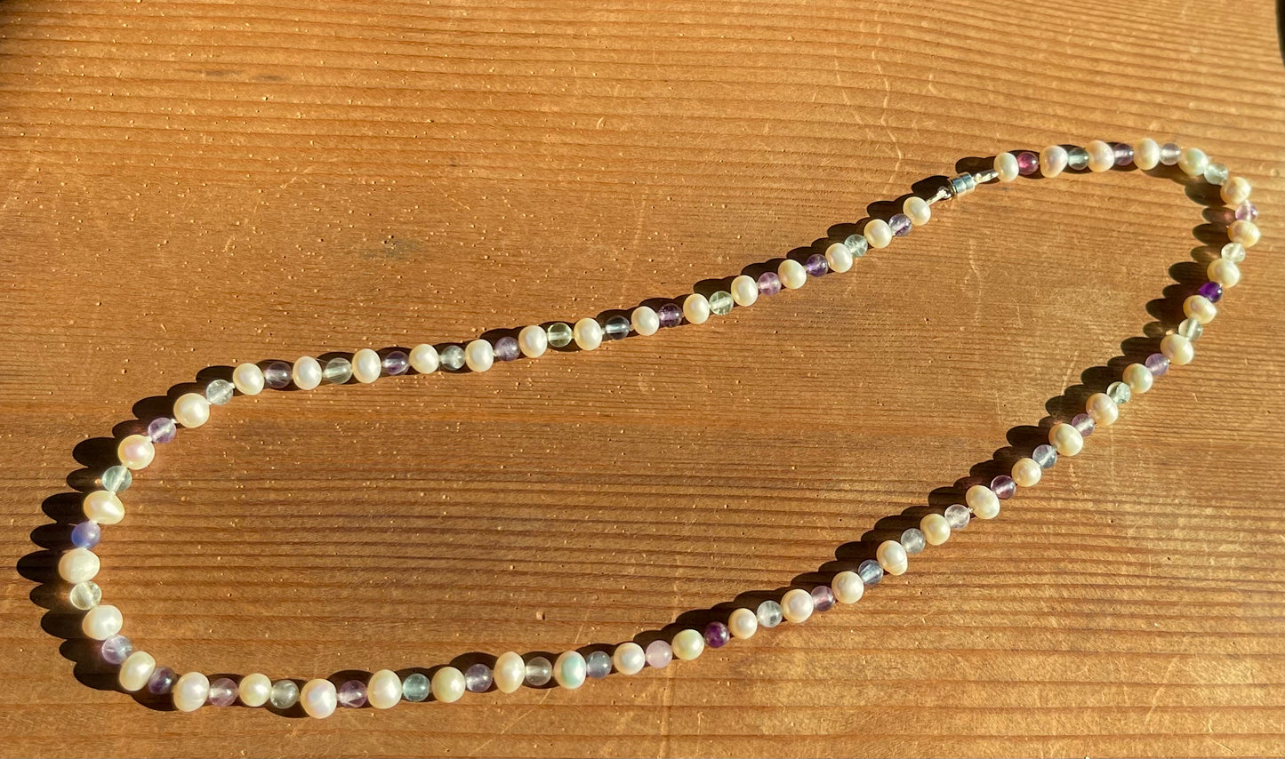 White Pearl and Fluorite Beaded necklace on a wooden surface