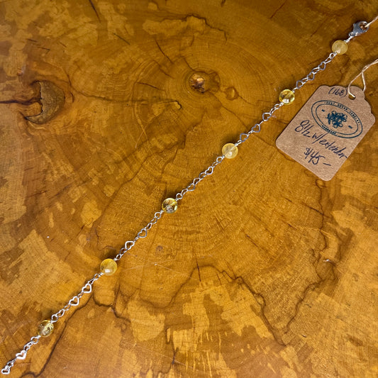 Faceted Citrine on Sterling Silver heart Chain, 8" with 1/2 " extender on a wooden surface with tag