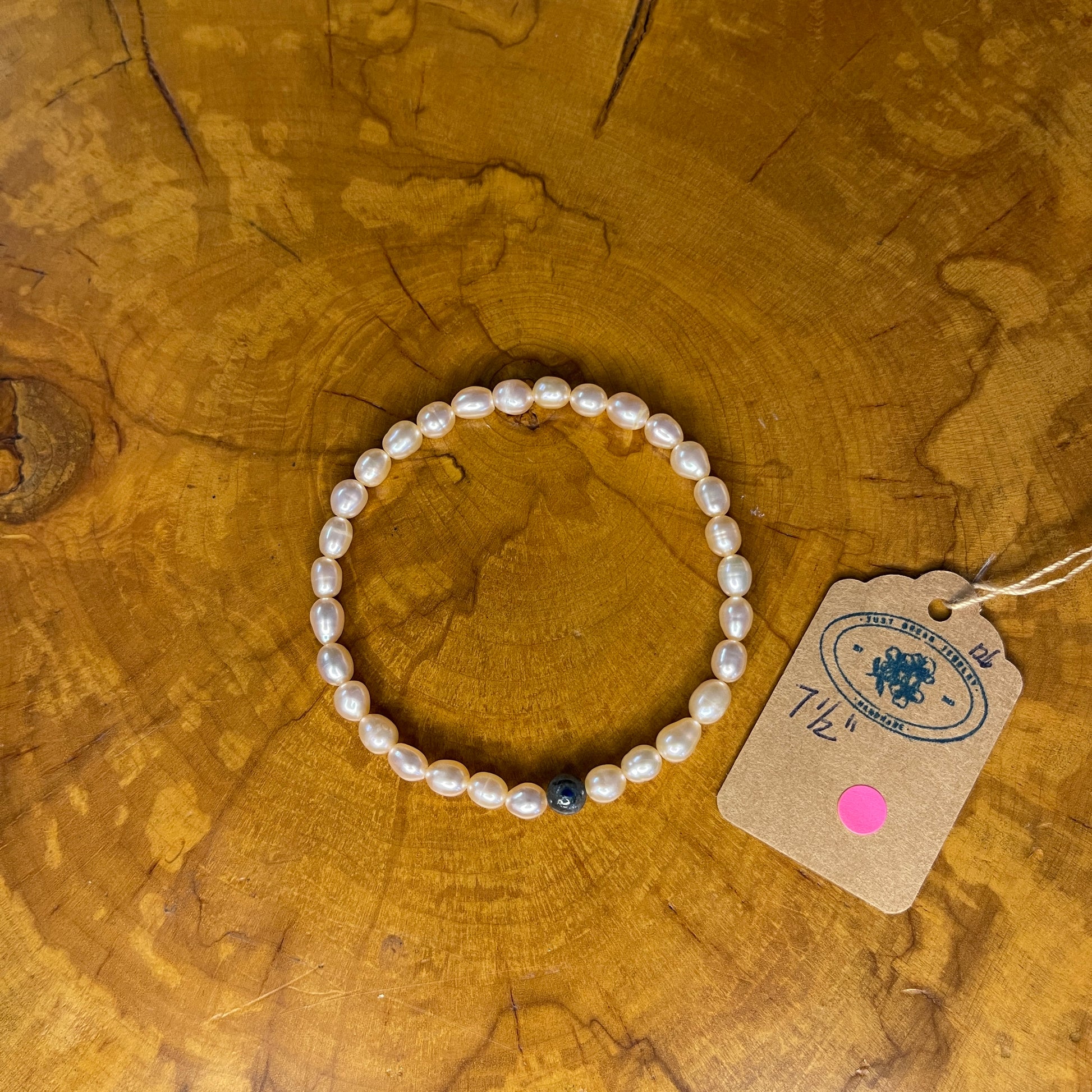 Mauve freshwater Pearls with Blue kyanite focus bead on elastic, 7 1/2" on elastic, 7 1/2" on wooden surface with tag