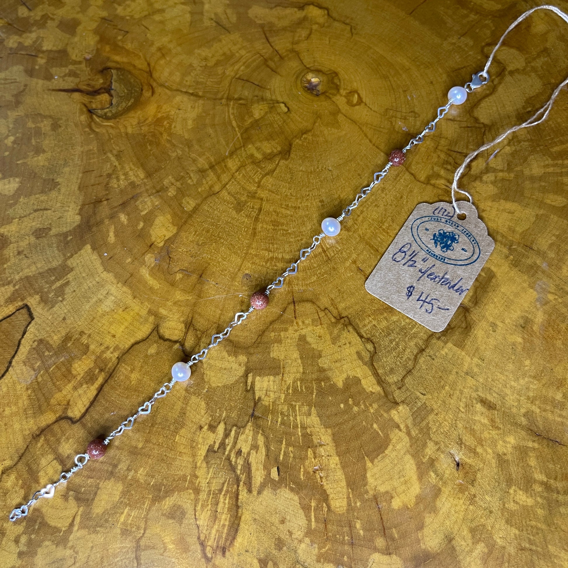 Goldstone and Freshwater Pearl on Sterling Silver Heart chain , Sterling Silver lobster clasp,8 1/2" on wooden surface with tag