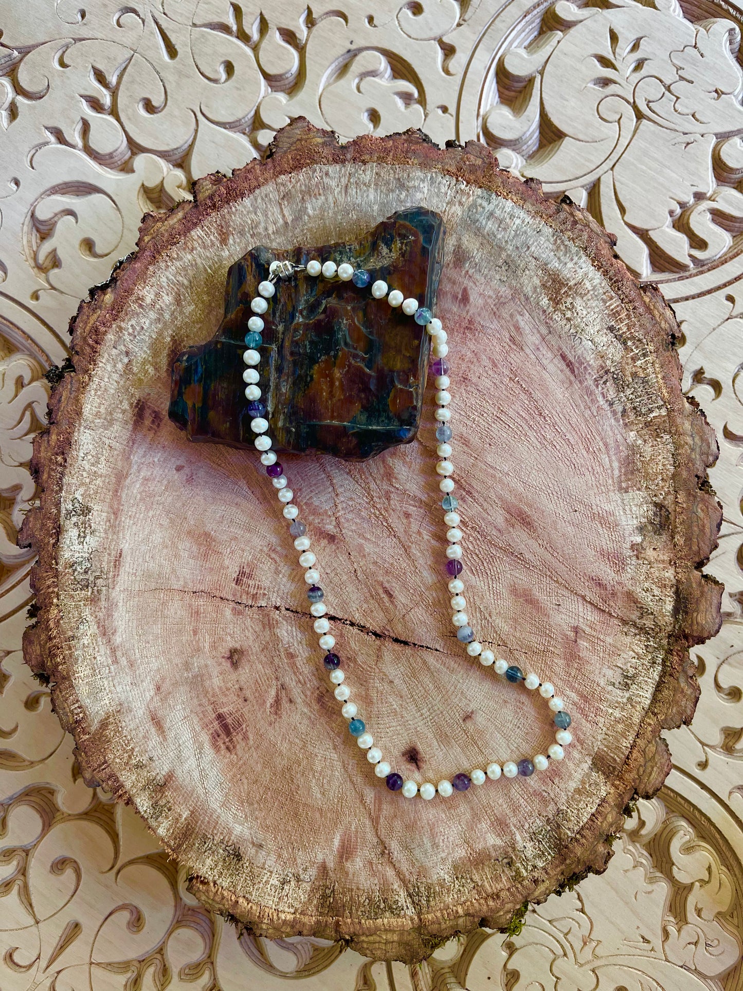 Pearl necklace with Fluorite beads on a light gray surface