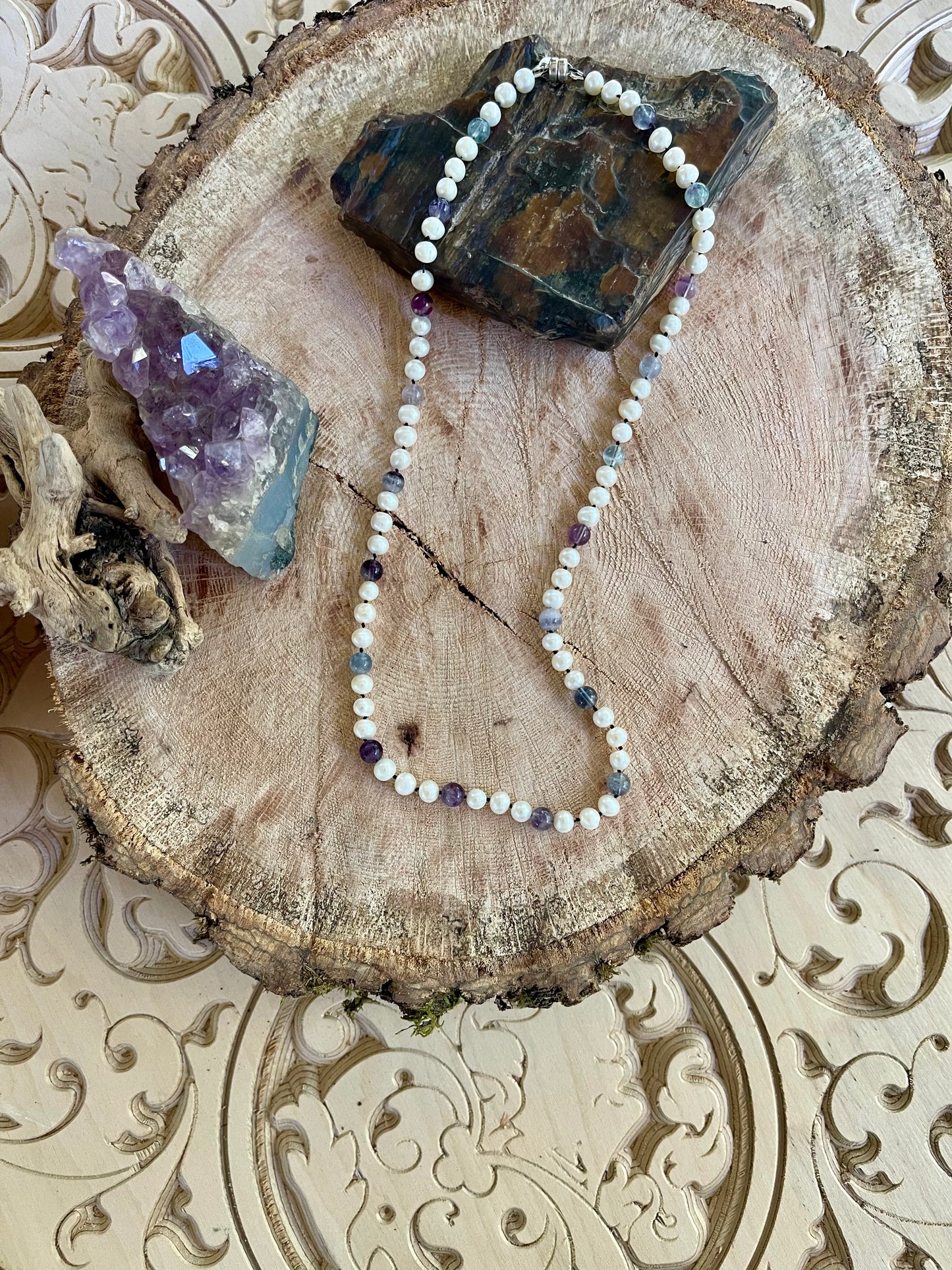 White Freshwater Pearl and Fluorite beaded Necklace on a wooden surface with crystals