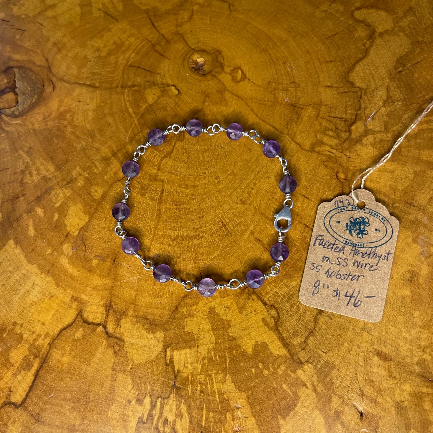 Faceted Amethyst on Sterling Silver wire with Sterling Silver Lobster clasp, 8" on wood
