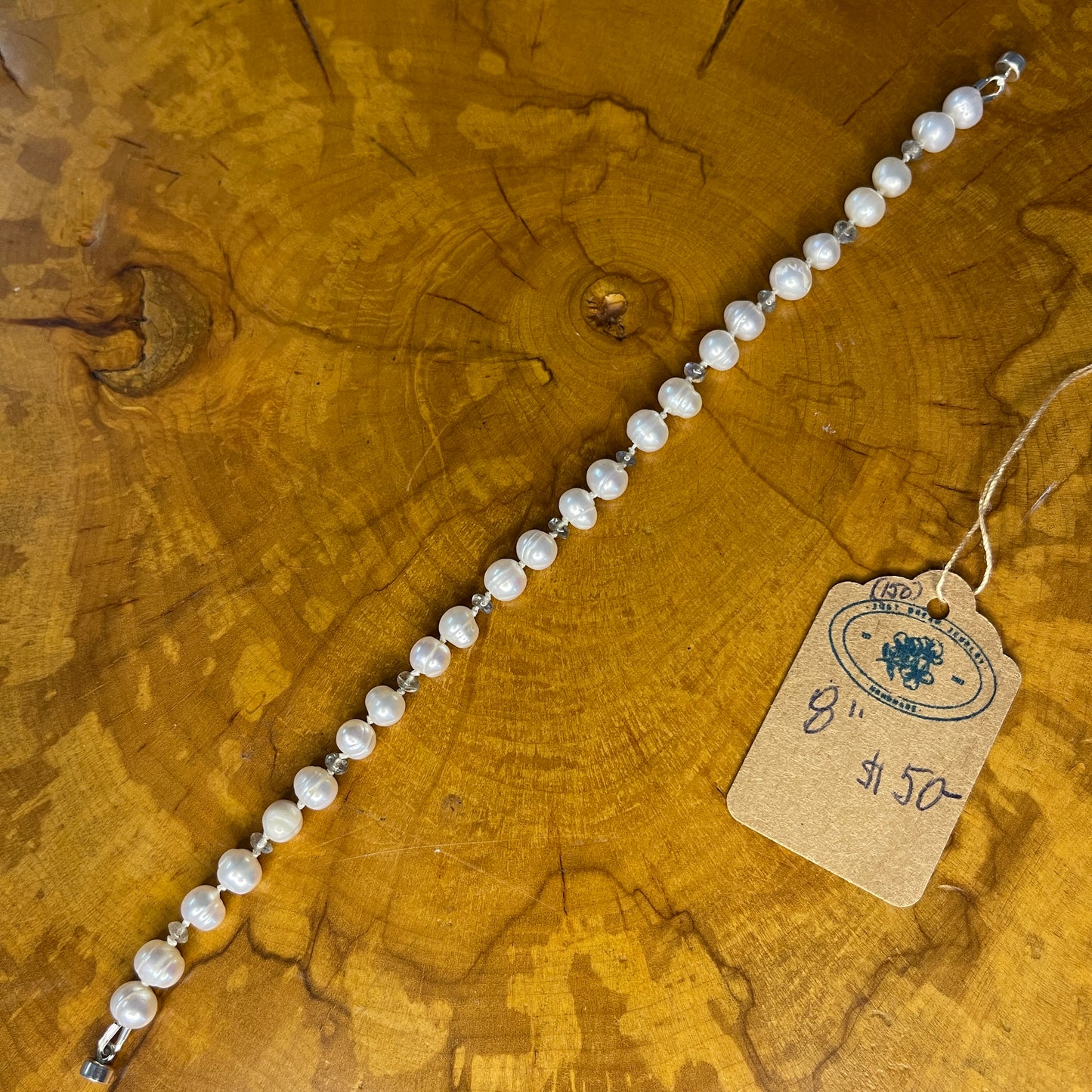 Freshwater White pearls with Opal seed beads on Silk with Sterling Silver Magnet clasp, 8" on a wooden surface with tag