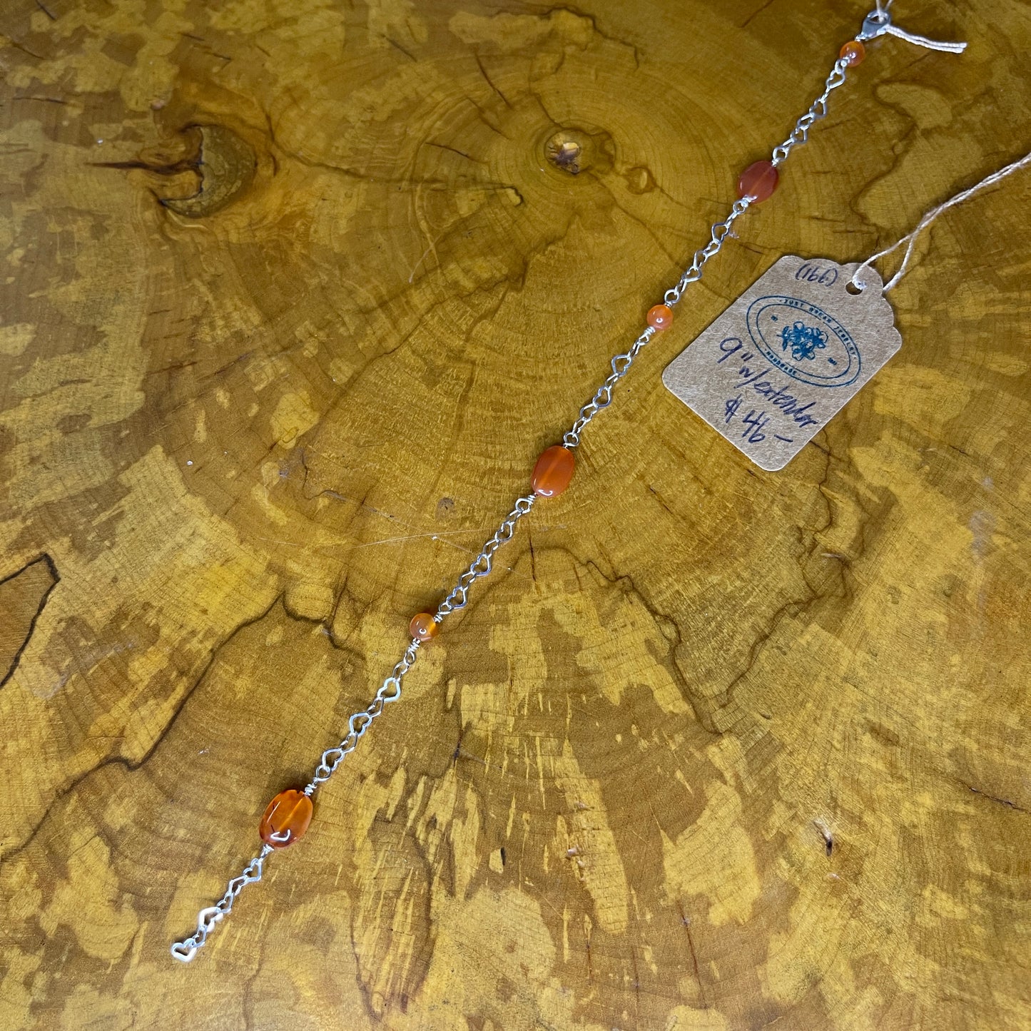 Carnelian Oval and Rounds on Sterling Silver Heart Chain, 8 inches with 1/2 inch extender, Sterling Silver lobster clasp on wooden surface with tag