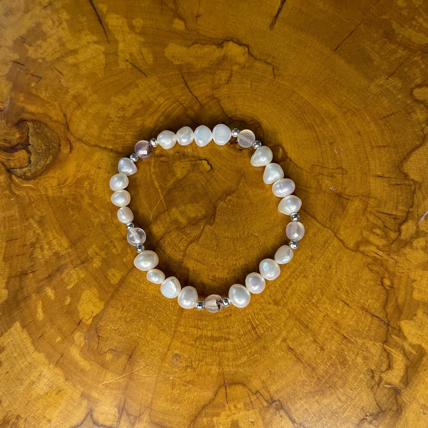 White freshwater Potato Pearls with Pink faceted Jasper on elastic, 7 1/2"on a wooden surface
